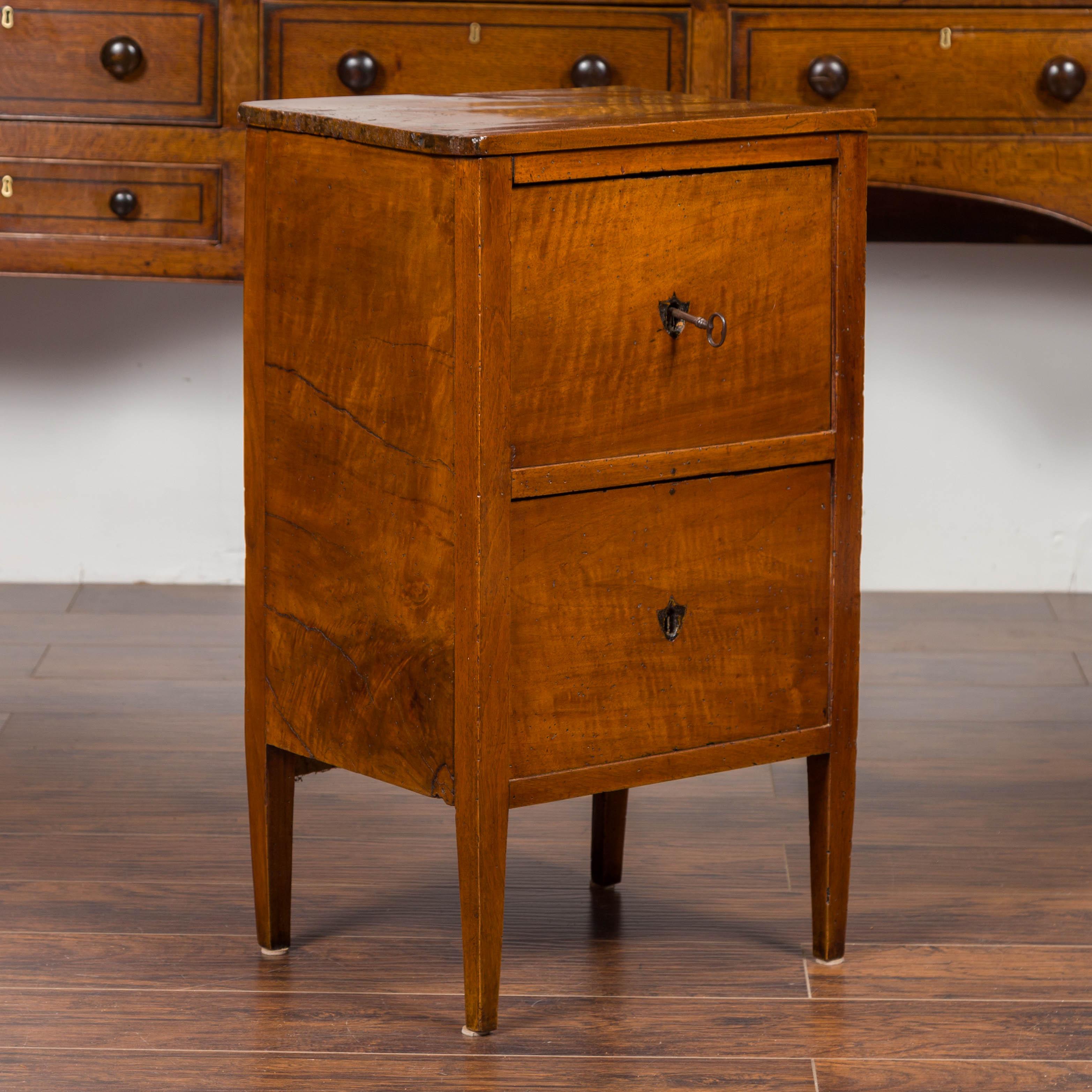 A petite Austrian Biedermeier period walnut commode from the mid-19th century, with two drawers and shield-shaped escutcheons. Born in Austria during the second quarter of the 19th century, this Biedermeier walnut commode features a rectangular top