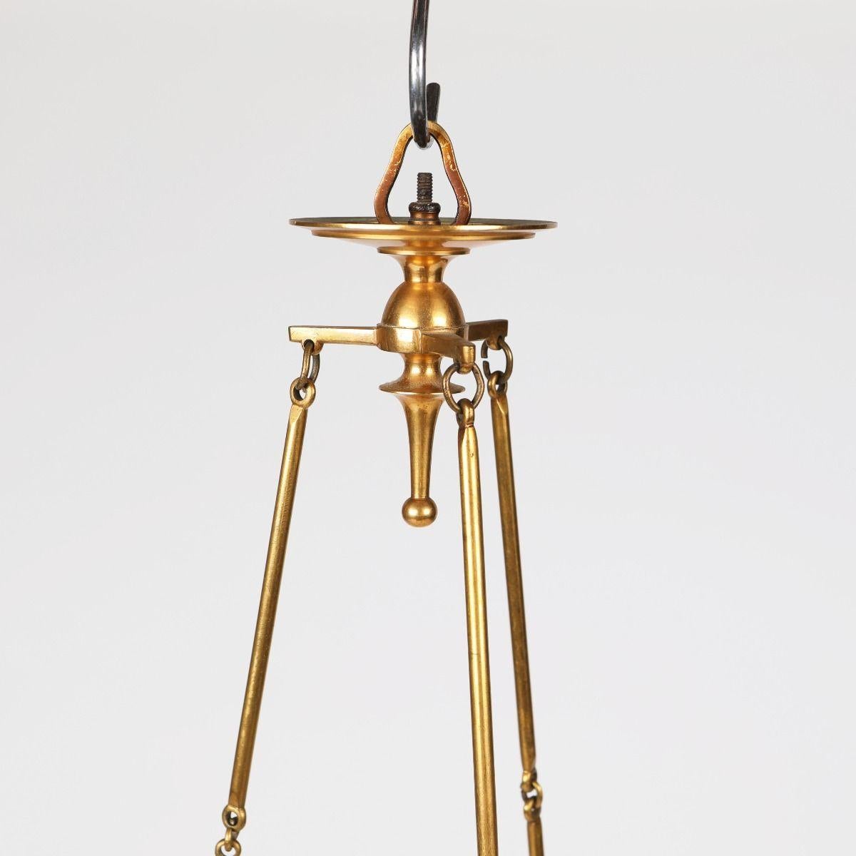 Petit lustre élégant et décoratif en laiton de style baroque, réalisé avec un travail de qualité.

Serait fabriqué par Skultuna.
Suède, vers 1920.