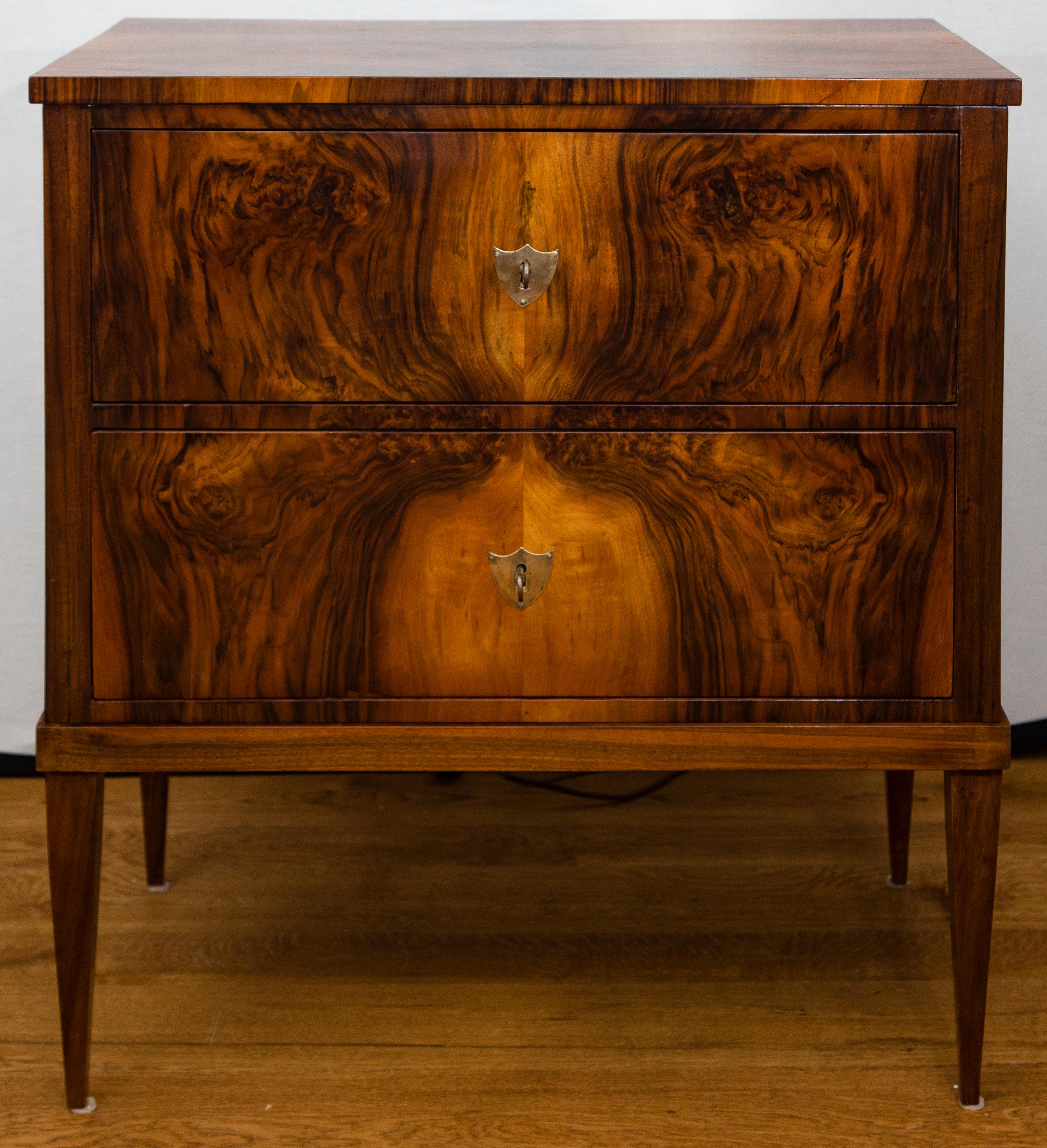 Smaller 19th century two drawer chest of drawers finishing on high tapered legs with shield-shaped brass escutcheons in a lovely patterned book-matched walnut veneer on pine.
Dating: 1840ca
Origin: Germany
Condition: Excellent restored condition