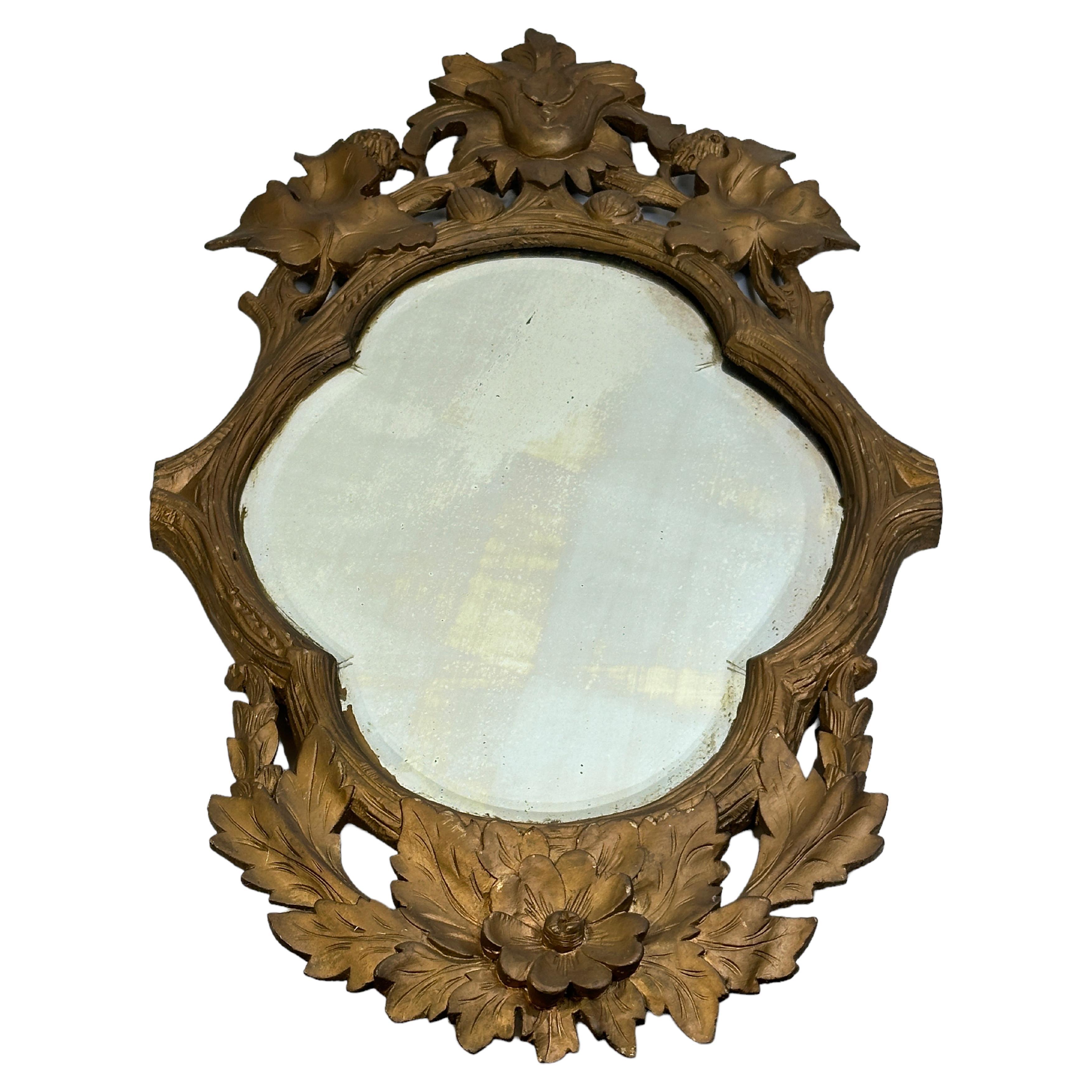 A most impressive german late 19th century gilded wood carved frame mirror circa 1890s or older. The original mirror plate is framed within an oval mottled warm gilded border. The unique and extremely decorative frame displays natural wood and