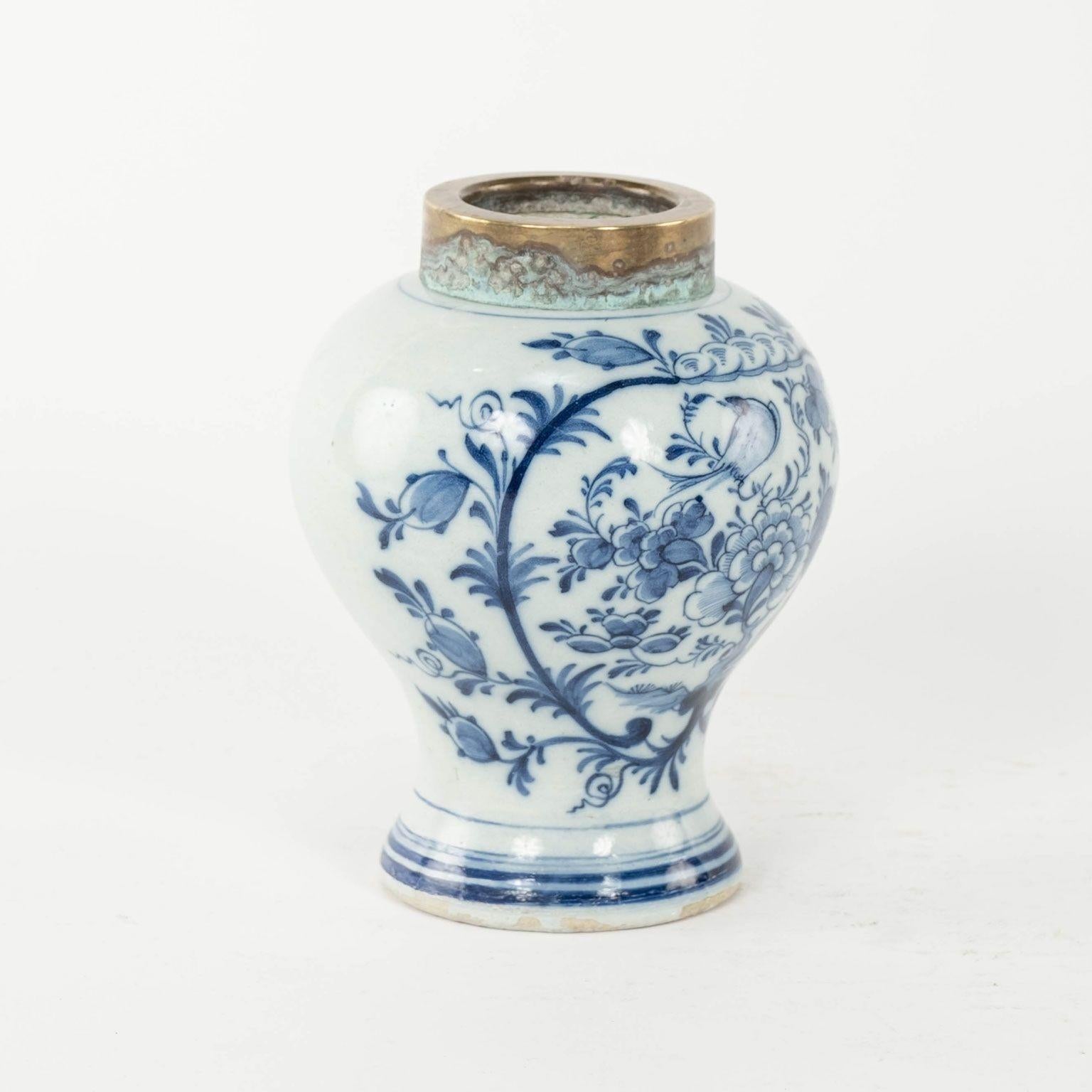 Petite blue & white delft tobacco jar with gilded metal rim circa 1830. Neoclassical scrolling floral decoration.

Note: Original/early finish on antique and vintage metal will include some, or all, of the following: patina, scaling, light rust,