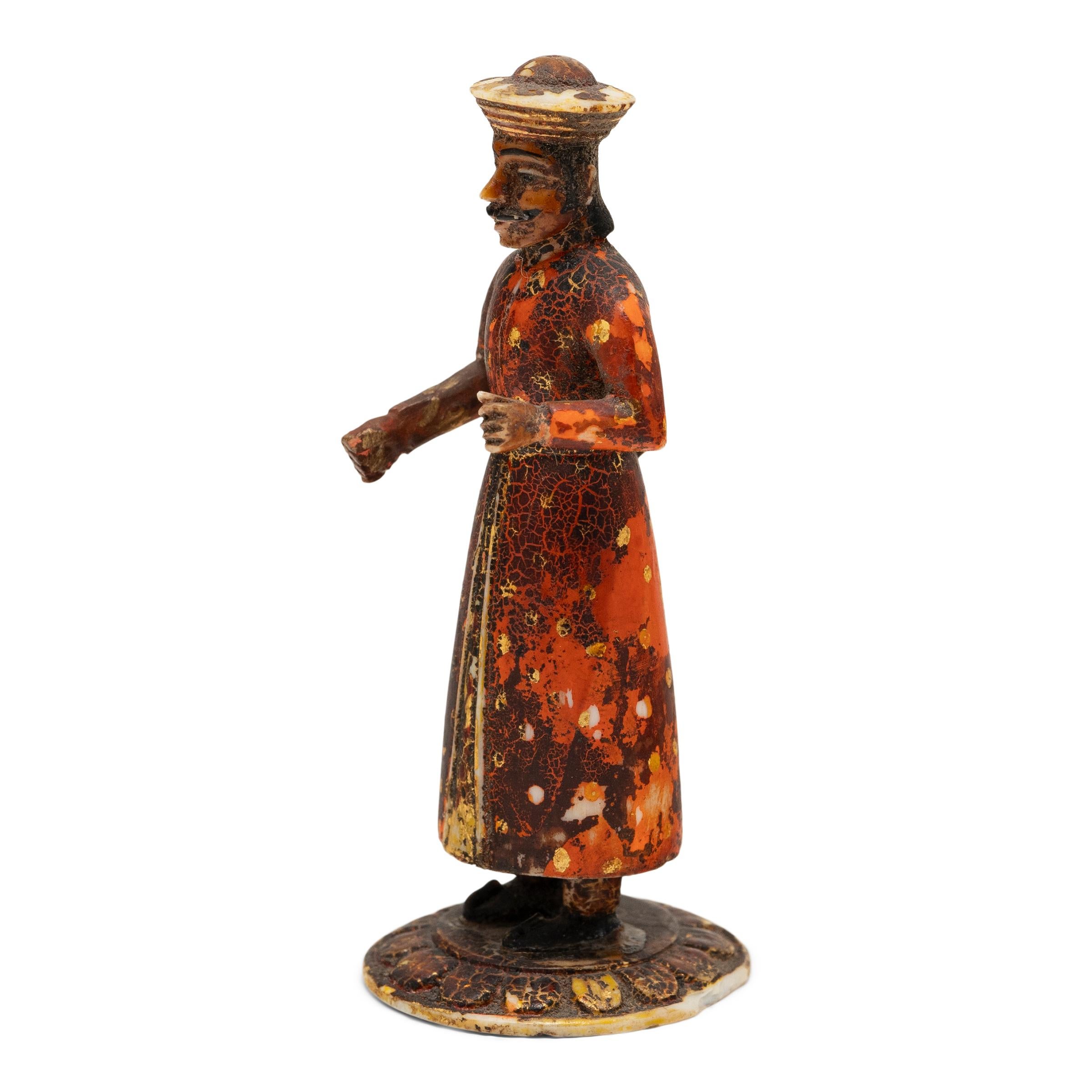 Cette figurine du début du XXe siècle est sculptée à la main dans de l'os et représente un soldat indien tenant un fusil à mousquet. Inspirée des cavaliers Sowar qui servaient sous la Compagnie britannique des Indes orientales, la petite figurine