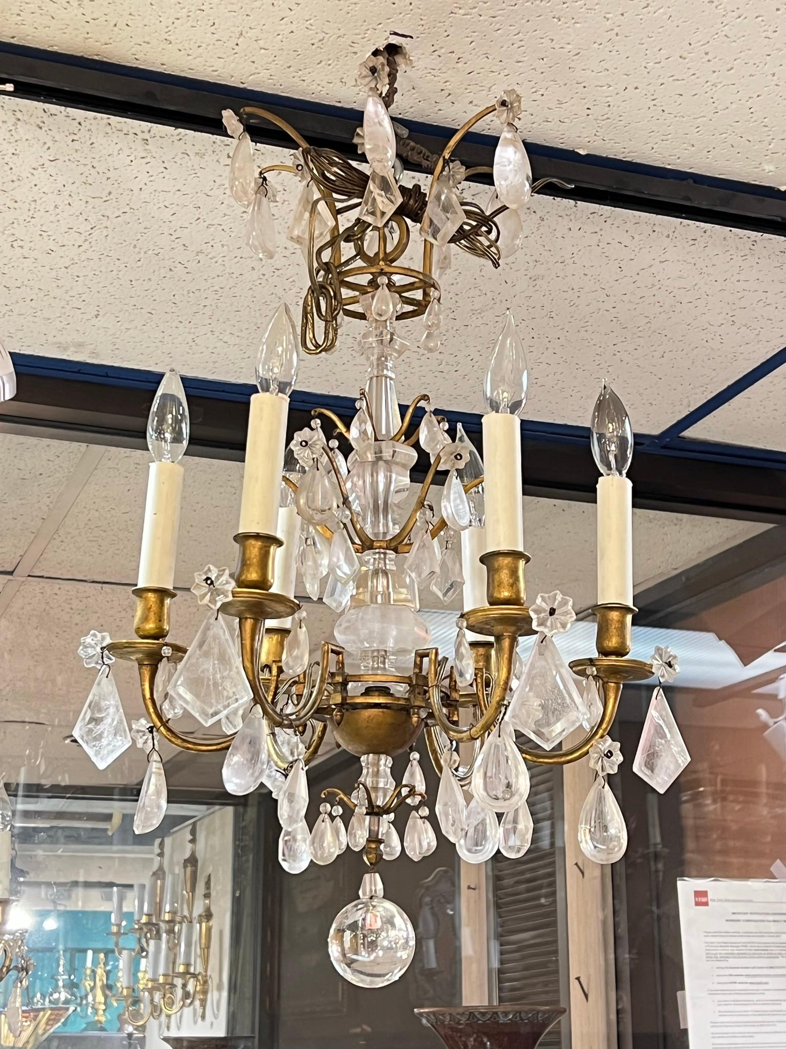 Petite 19 century  French bronze chandelier with rock crystal stem and numerous rock crystal pendants, with six electrified candle arms and modern wiring, ready for use.