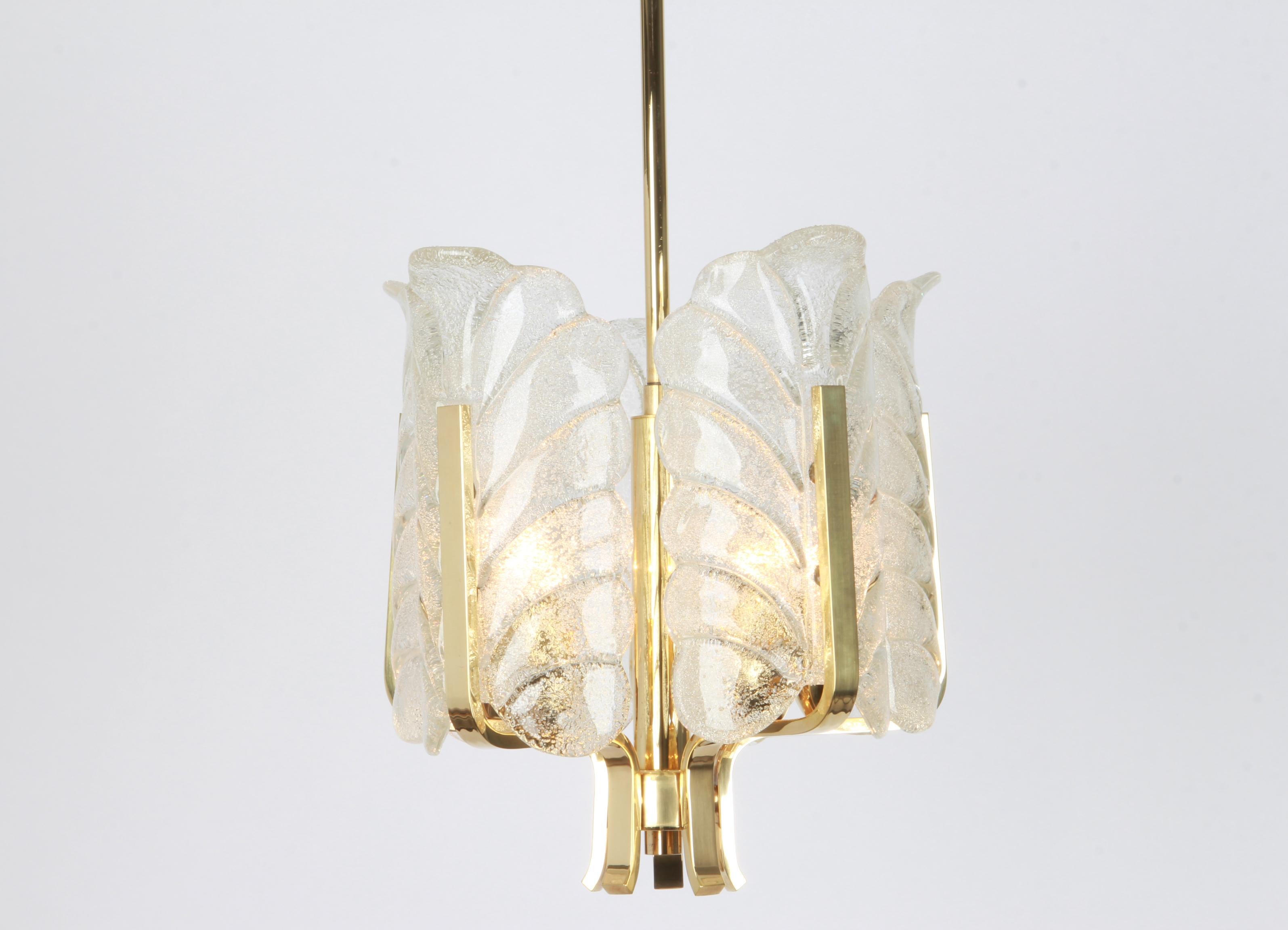 Very glamorous chandelier designed by Carl Fagerlund for Orrefors glass, Sweden, manufactured in midcentury, circa 1960-1969. The light features a polished brass frame with five stunning Orrefors glass leaves which have a matte frosted relief on the