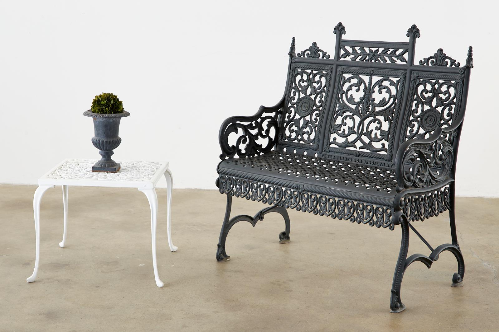 Gothic Revival style petite cast iron garden bench after Peter Timmes and Son's famous bench that is displayed in the Brooklyn and Metropolitan museum and art. Signed Peter Timmes Son Brooklyn, NY on the front and stamped pat. May 7, 1895 on the