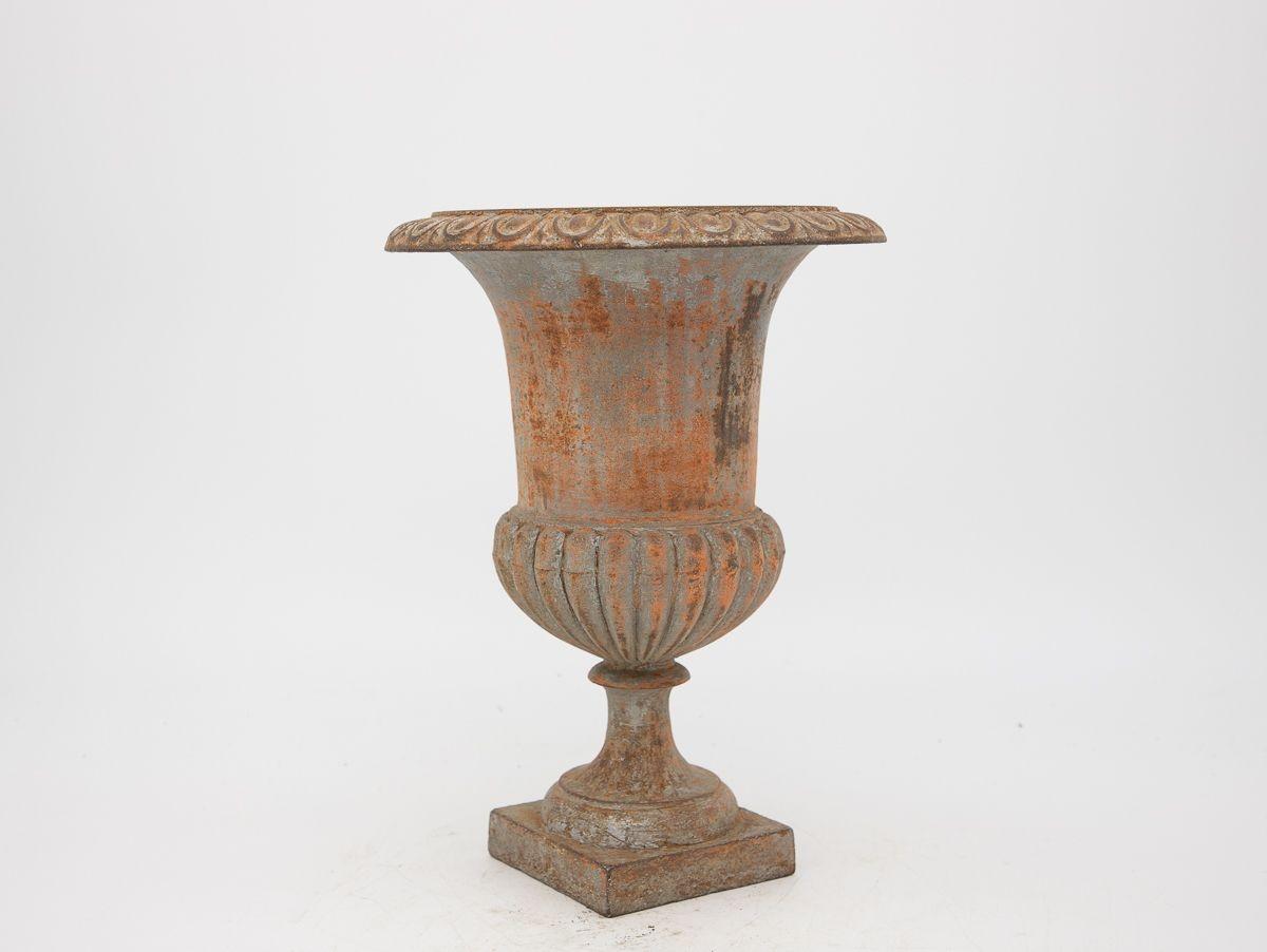A mid-20th century gray painted cast iron urn. This urn features an egg and dart pattern on the top rim and a fluted bottom on a square base. Some paint loss, rust spots, wear consistent with age and use.
