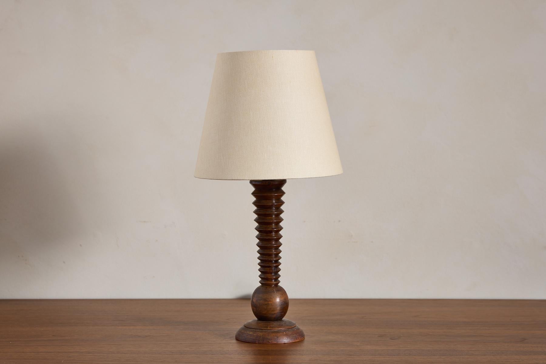 Petite lampe de table Charles Dudouyt avec sa signature en forme de tire-bouchon et sa base en forme de boule. 

Merveilleuse patine d'usage et petite taille.

Nouveau câblage et nouvel abat-jour en lin.

France, années 1940