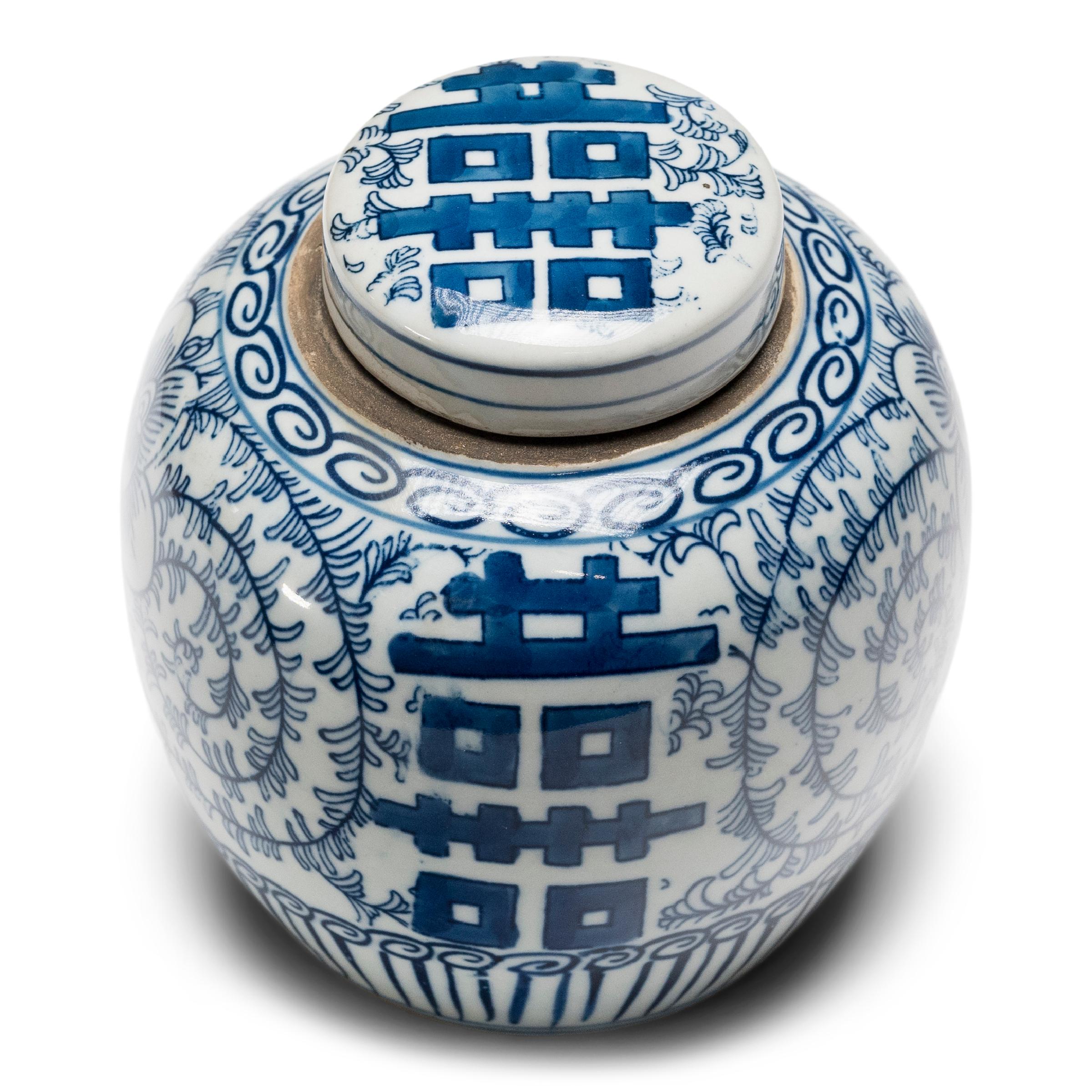 The symbol for double happiness adorns this small tea leaf jar with best wishes for love, companionship and marital bliss. Glazed in the classic blue and white manner, the small porcelain jar has a rounded form and flat lid, a traditional shape for
