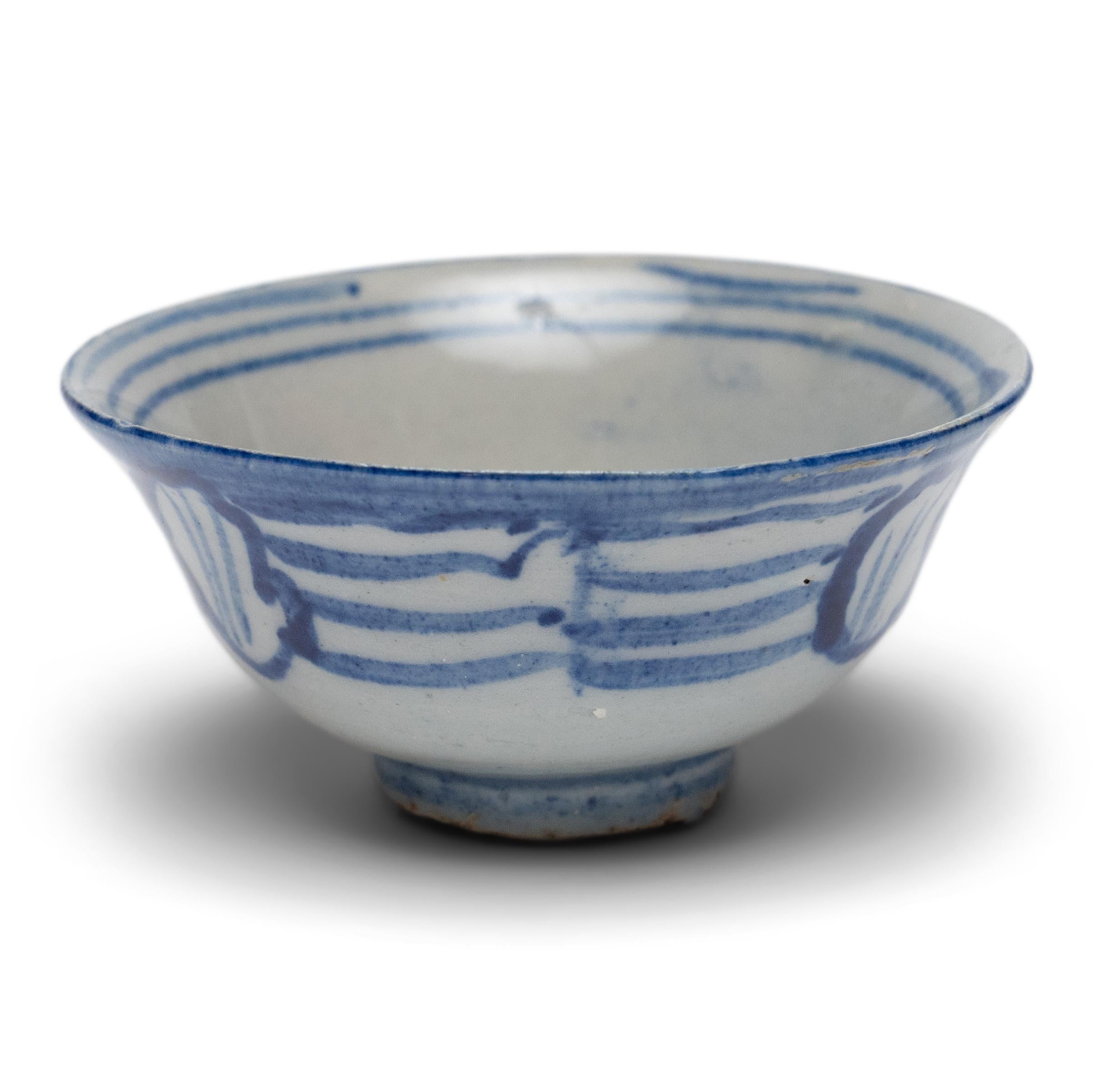 An everyday example of Chinese blue-and-white ceramics, this petite cup from the late Qing dynasty is appreciated for its delicate simplicity and charming imperfections. Used for drinking tea or rice wine, the small cup has a tea-bowl silhouette,