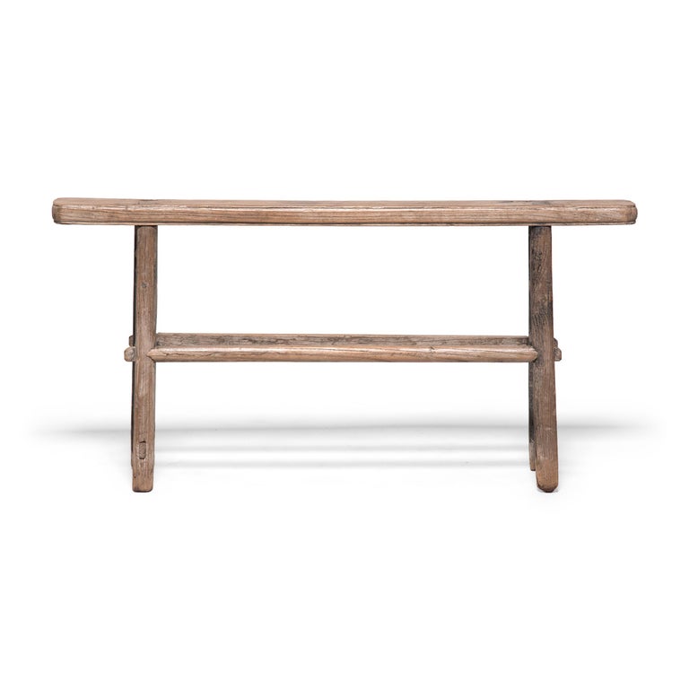 Crafted at the turn of the century, this petite bench is simply designed with clean lines and little decoration. Given its short stature and narrow frame, this bench was likely a versatile step stool. Moved throughout the home as needed, the bench
