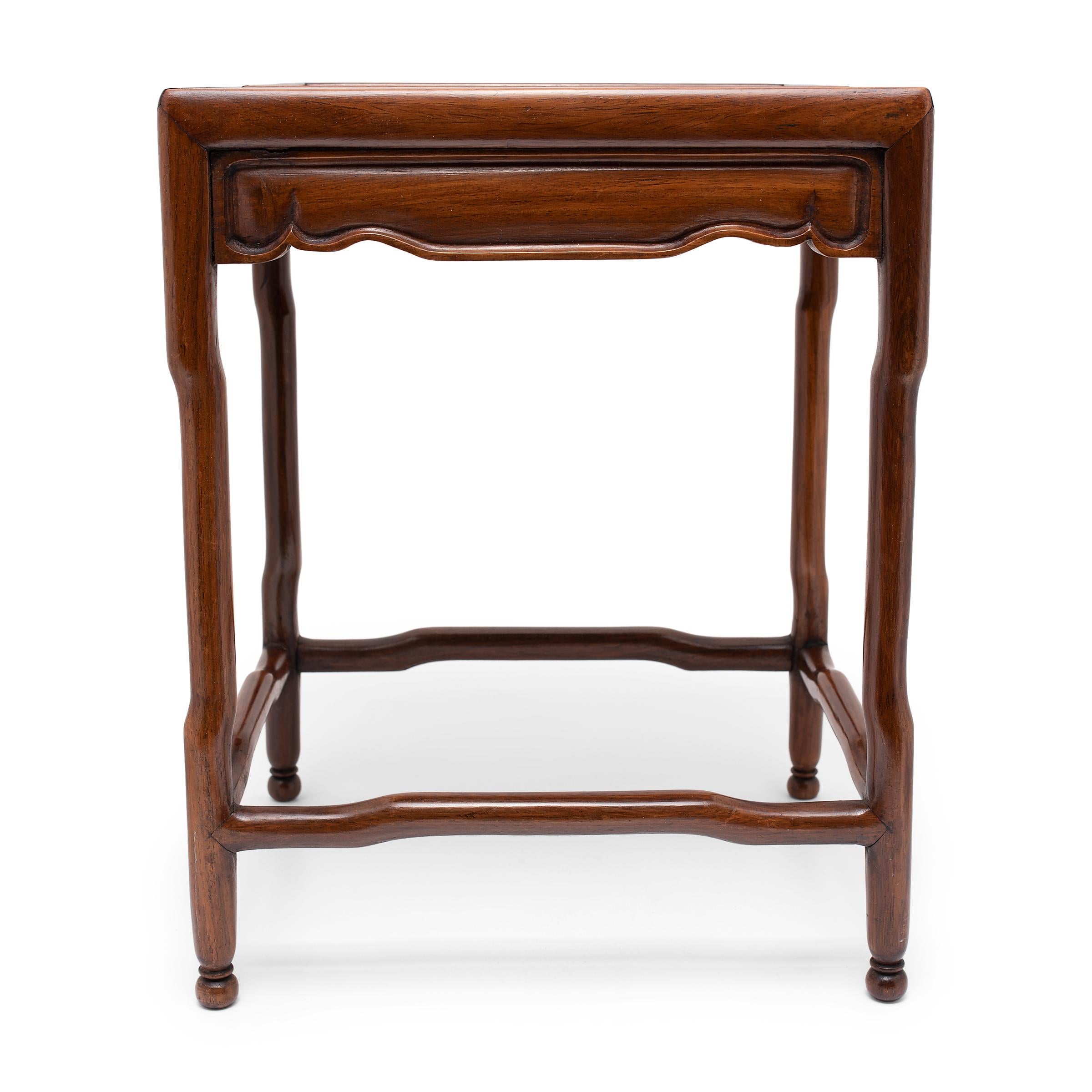 Crafted of a beautiful dense hardwood, this petite table from the late 19th century is designed for displaying precious objects, such as fine porcelain, sculptures, or incense burners. The pedestal has a rectangular floating panel top and stands on
