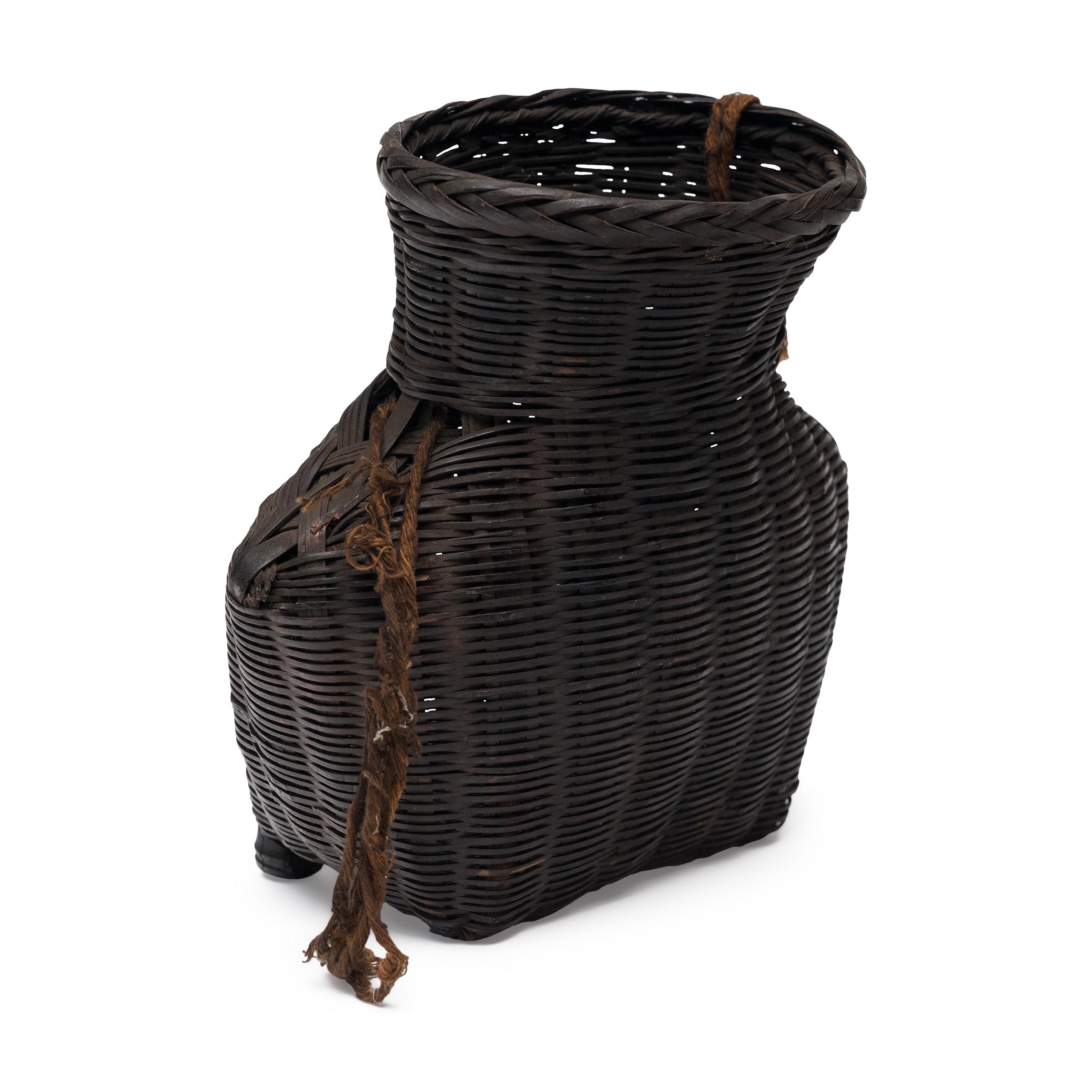 Tejida con preciosa escama y delicado arte, esta pequeña cesta de bambú de principios del siglo XX es un bello ejemplo de la cestería tradicional china. Hecha a mano en el suroeste de China, la pequeña cesta portátil se colgaba de la cintura como un