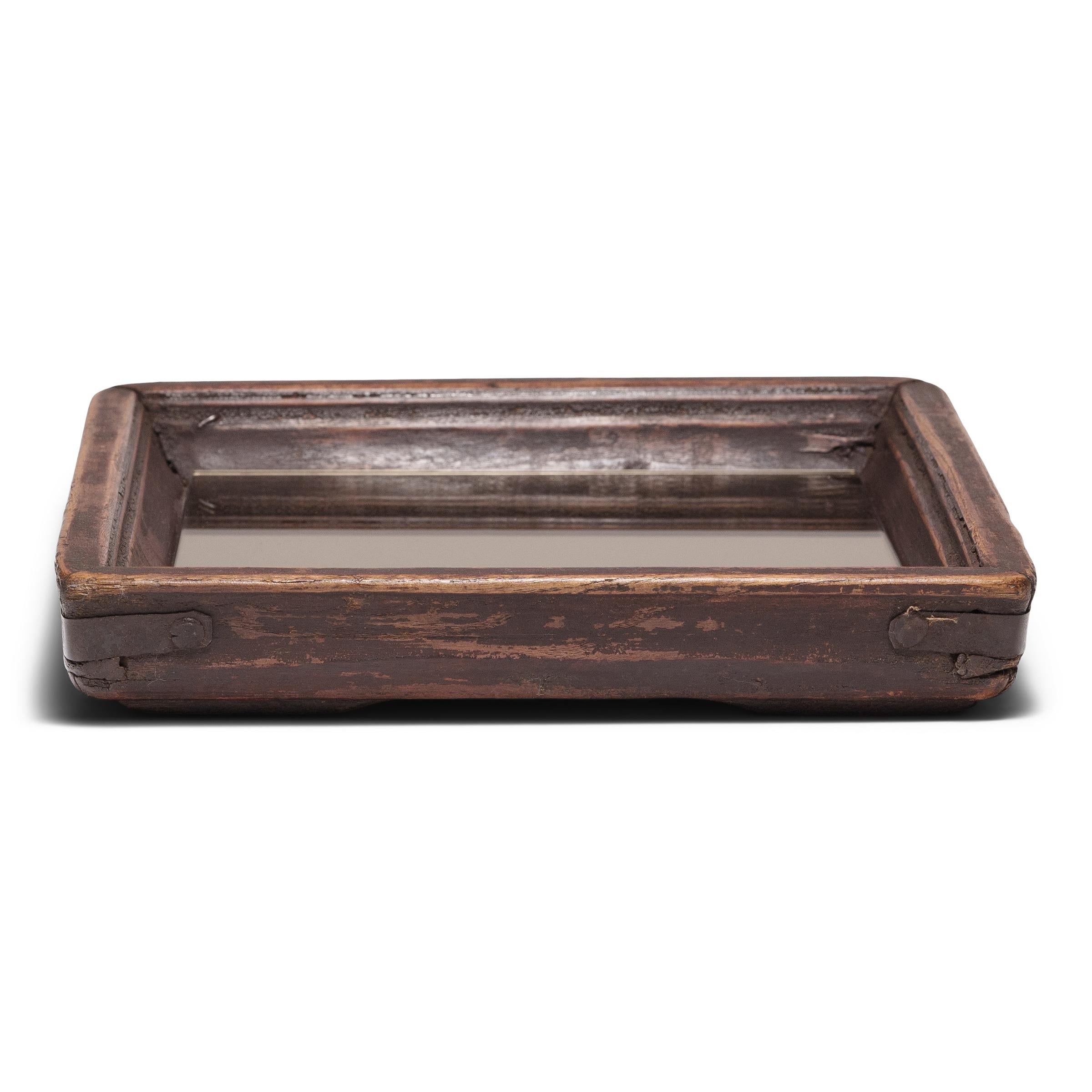 Einfache Linien, eine schlichte Form und eine Schicht aus handgebürstetem Lack verleihen diesem zierlichen Holztablett einen provinziellen Charme, der an die Wärme der Heimat erinnert. Das quadratische Tablett hat eine charaktervolle schwarze