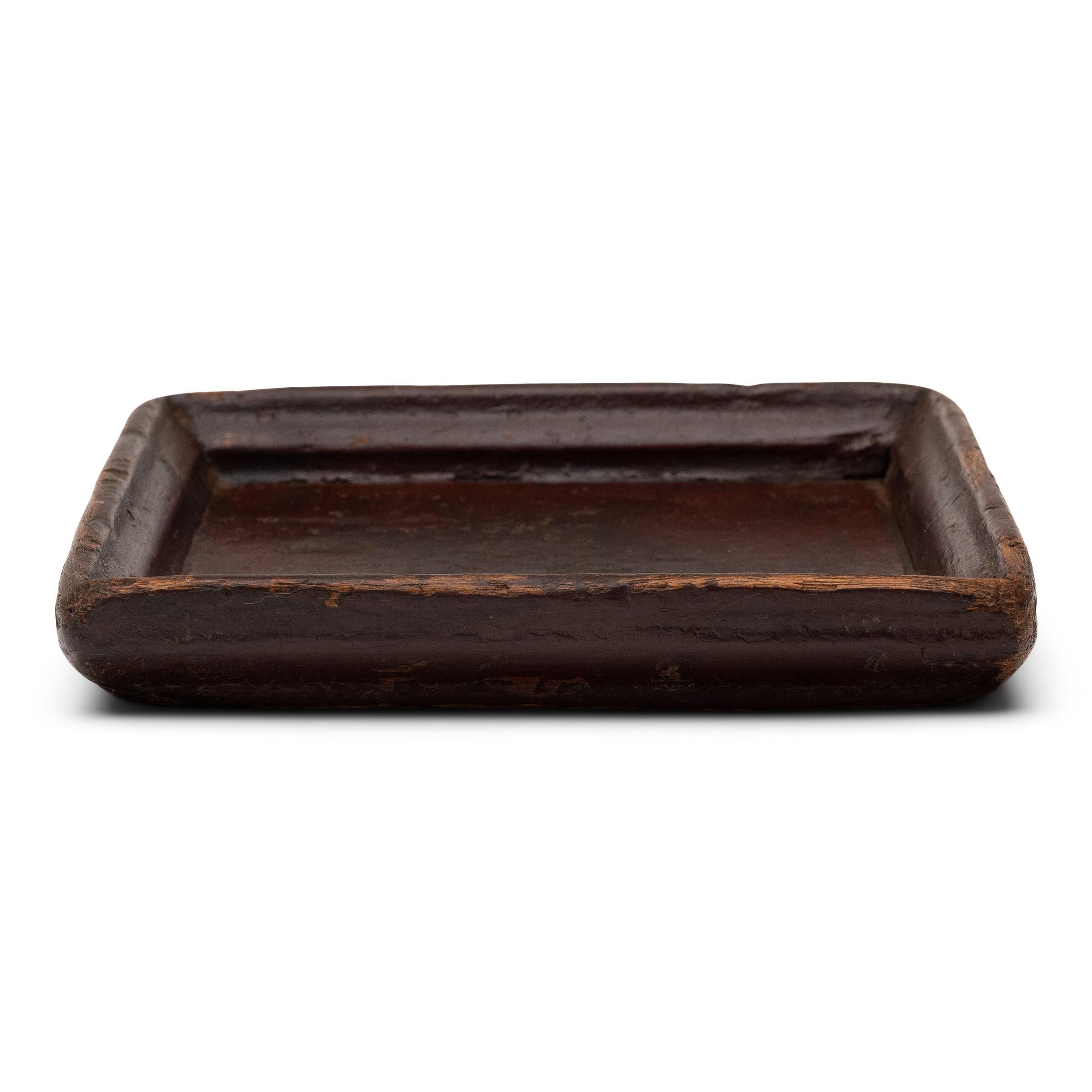 Simple lines, a modest form and a layer of hand-brushed lacquer give this petite Qing-dynasty tray a provincial charm that recalls the warmth of home. The original burgundy lacquer finish has weathered with time for a wabi-sabi feel, faded along the