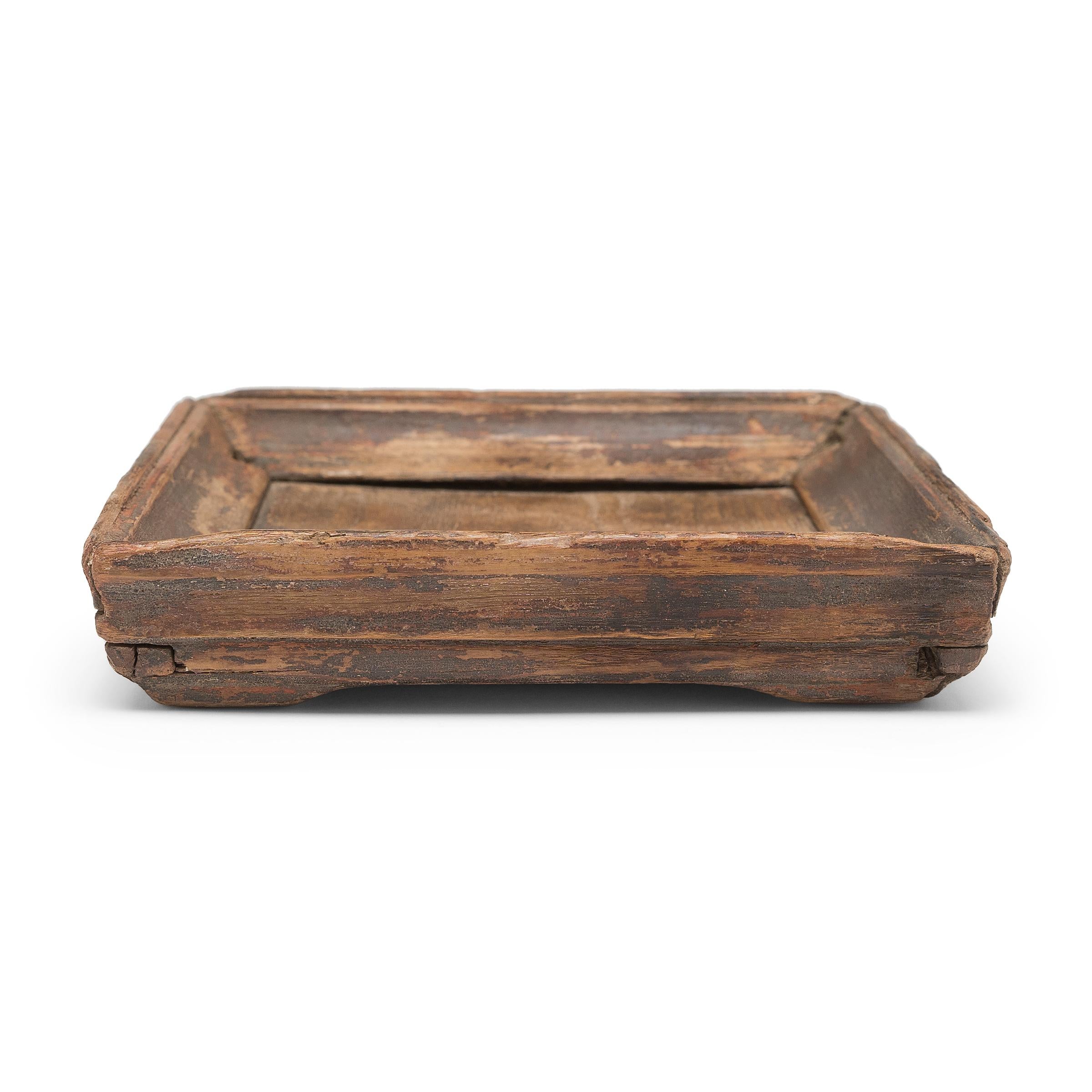 Simple lines, a modest form, and a layer of hand-brushed lacquer give this petite Qing-dynasty tray a provincial charm that recalls the warmth of home. The brown lacquer finish has weathered with time to reveal the light brown coloring of its pine