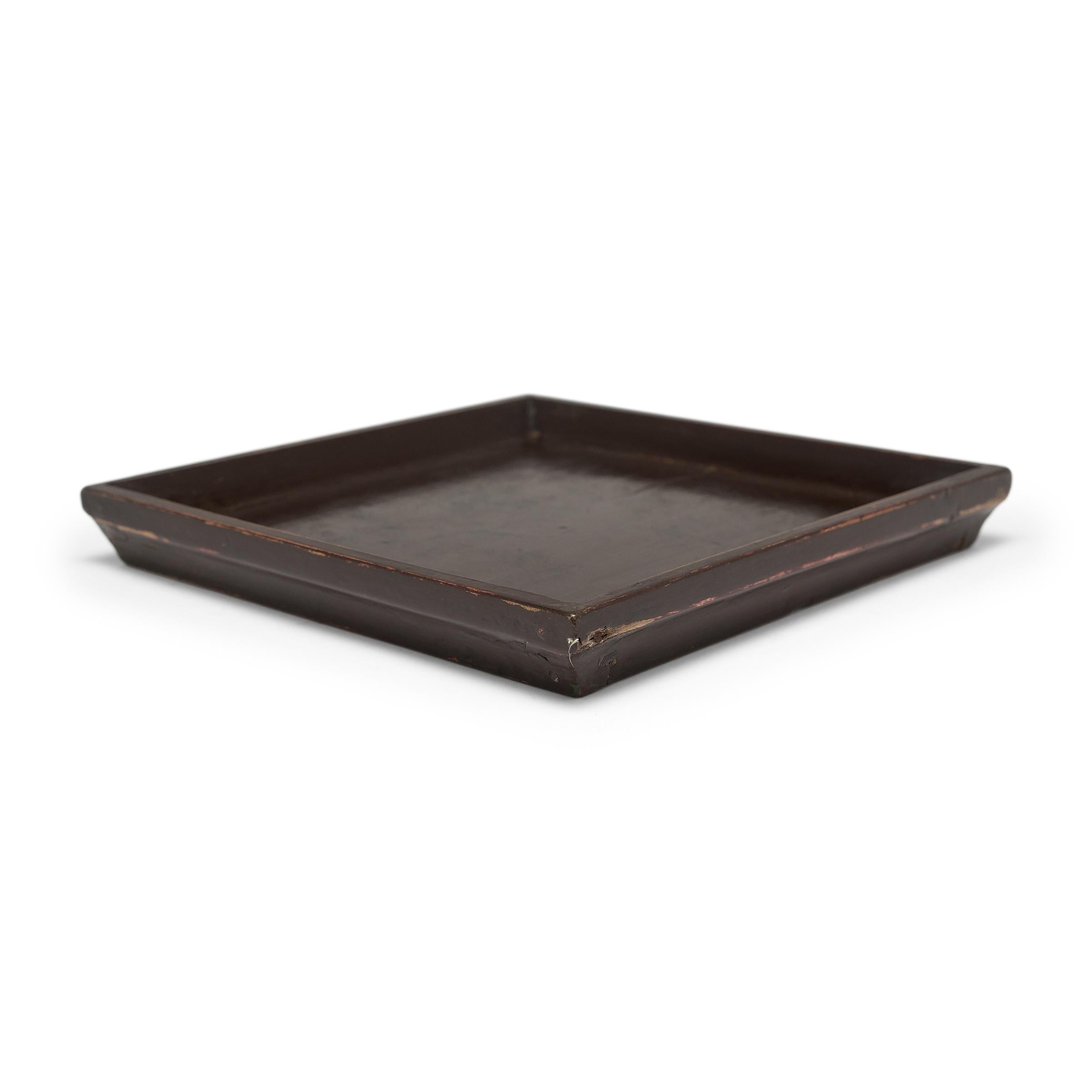Simple lines, a modest form, and a layer of hand-brushed lacquer give this petite Qing-dynasty tray a provincial charm that recalls the warmth of home. The dark brown lacquer still holds its glossy finish with some weathering with that reveals the