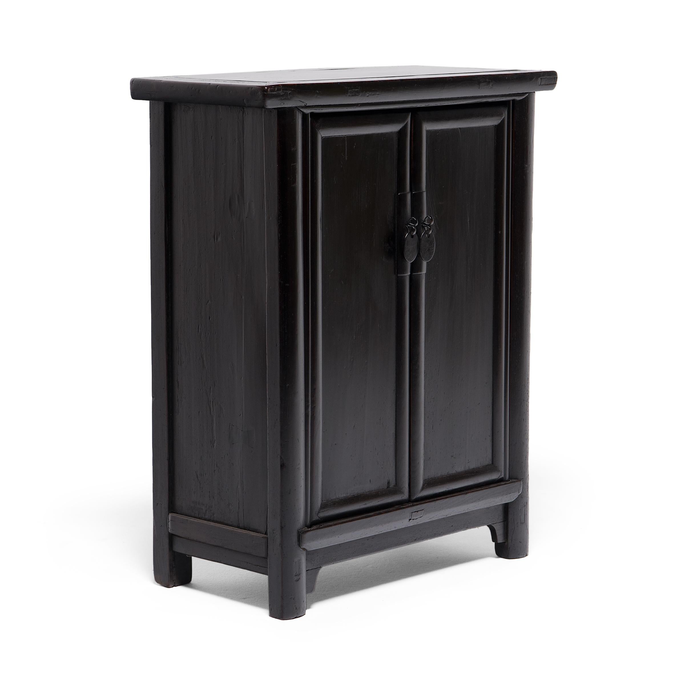 The quiet elegance of this small cabinet is thanks to its clean lines and balanced proportions. Dated to the late 19th century, this cabinet is designed to resemble the classic upright noodle cabinet, with a slight overhang, rounded edges, and two