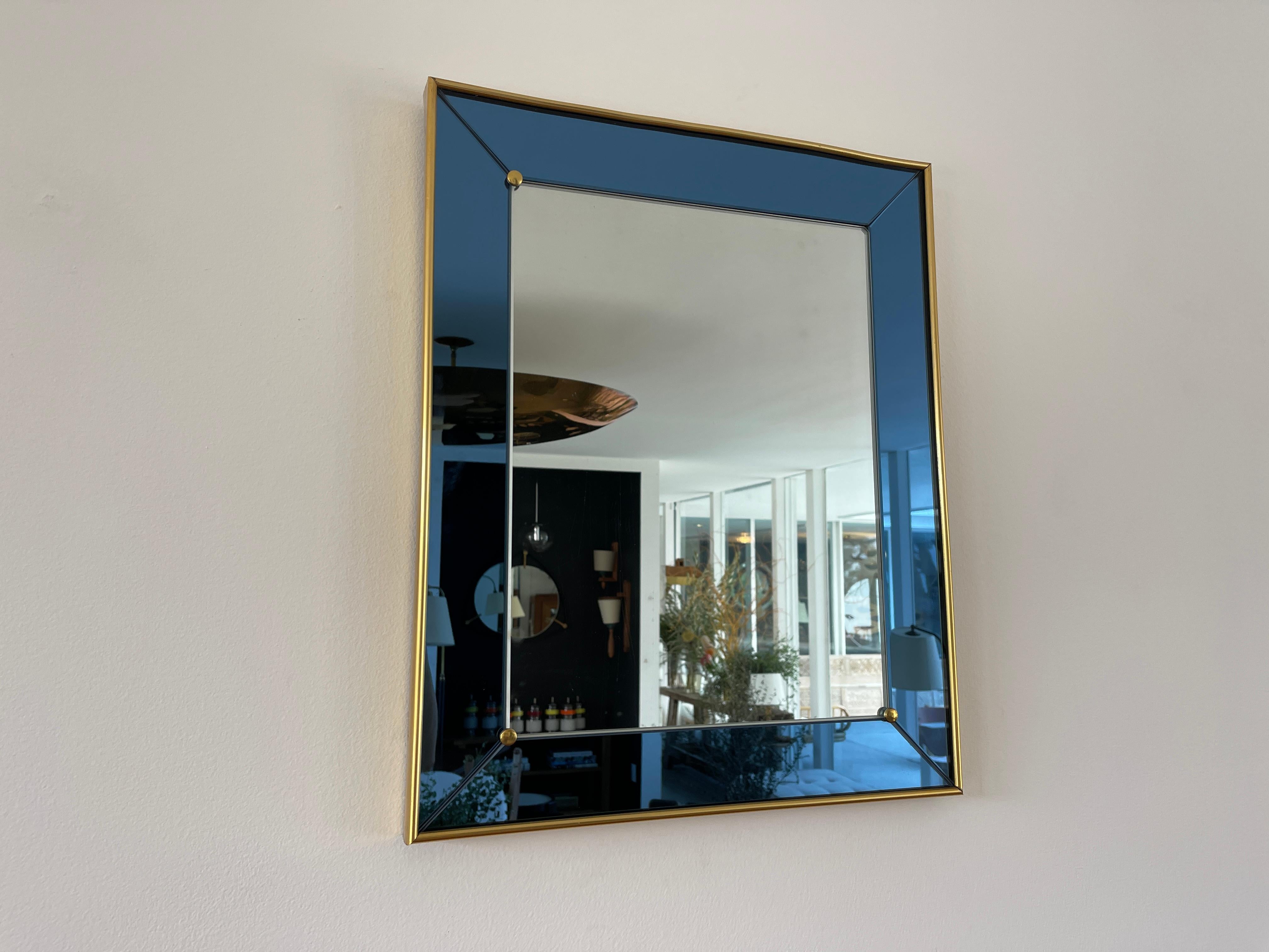 Cristal Art mirror with royal blue glass and brass frame / hardware. 
Italy, circa 1970s