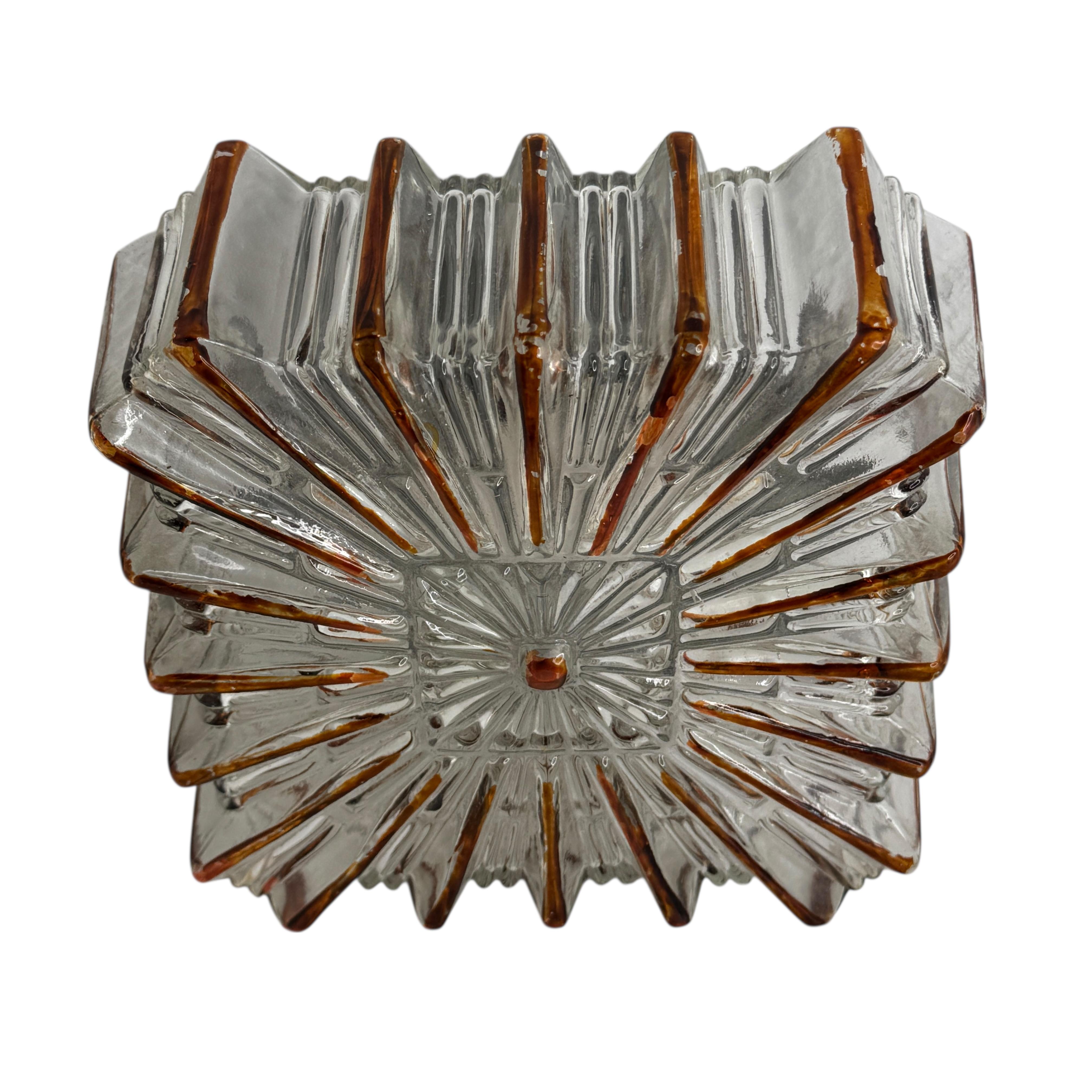 Beautiful starburst pattern flush mount. Made in Germany by Glashuette Limburg. Gorgeous textured glass flush mount with metal fixture. The fixture requires one European E27 Edison bulb up to 75 watts.
Found at an Estate Sale in Nuremberg, Germany.