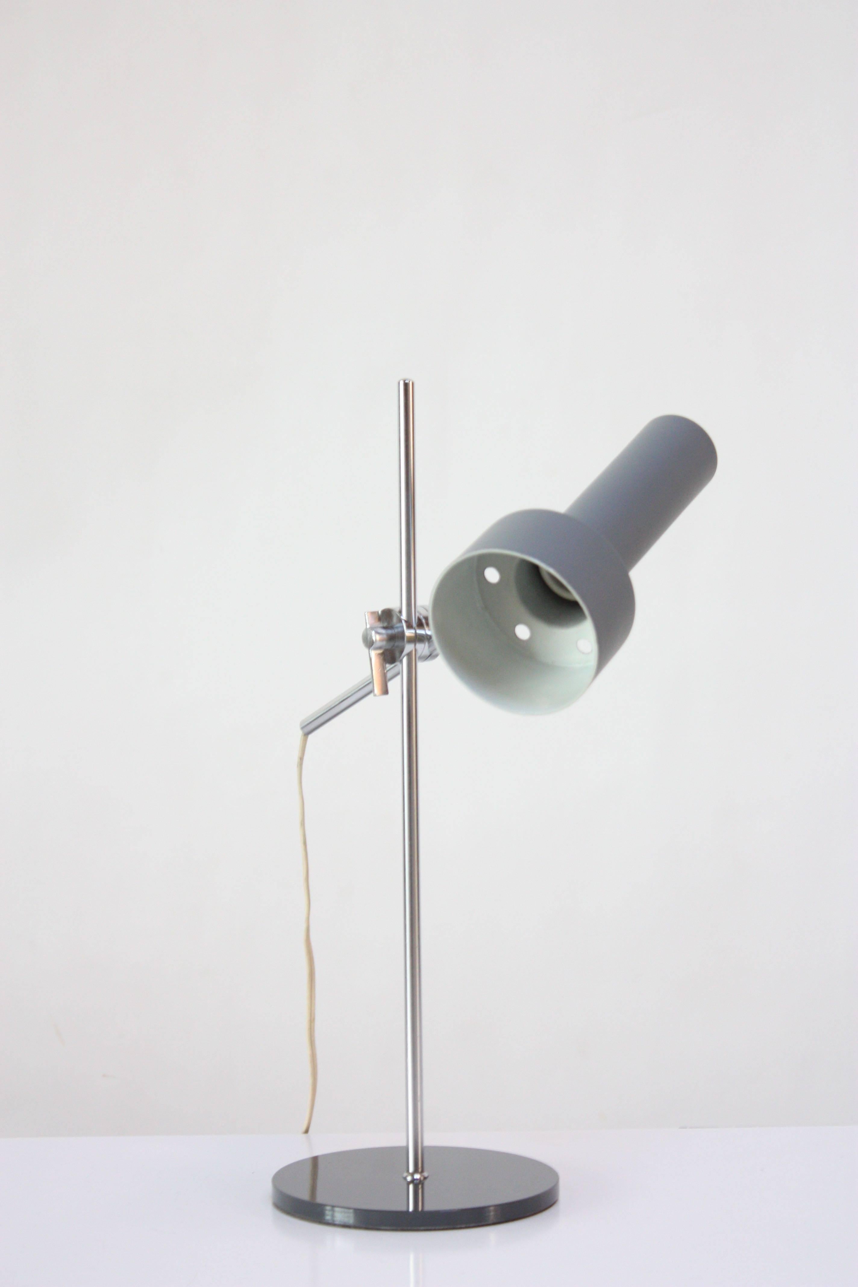 Diminutive 1960s Danish modern table lamp composed of a chromed-metal stem, arm and adjustment clasp, and a circular, blue-grey painted metal base and shade. Features full shade and arm height adjustability. Measures: Height goes from 18.25