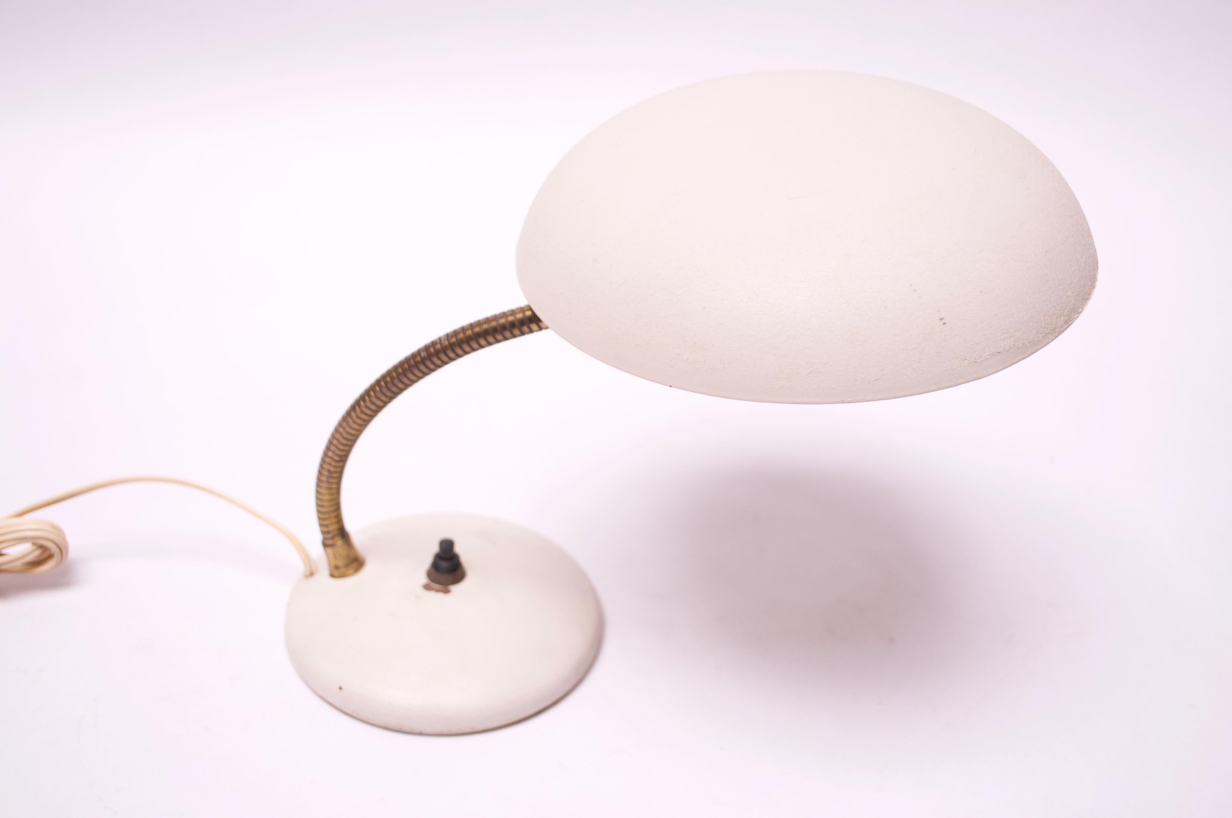 Petite fully adjustable table lamp in original off-white metal. Saucer shade can pivot in a full 365 degree rotation, and the gooseneck arm feature allows for full height adjustability.  Minor wear to white paint (scuffs to exterior shade, spots of