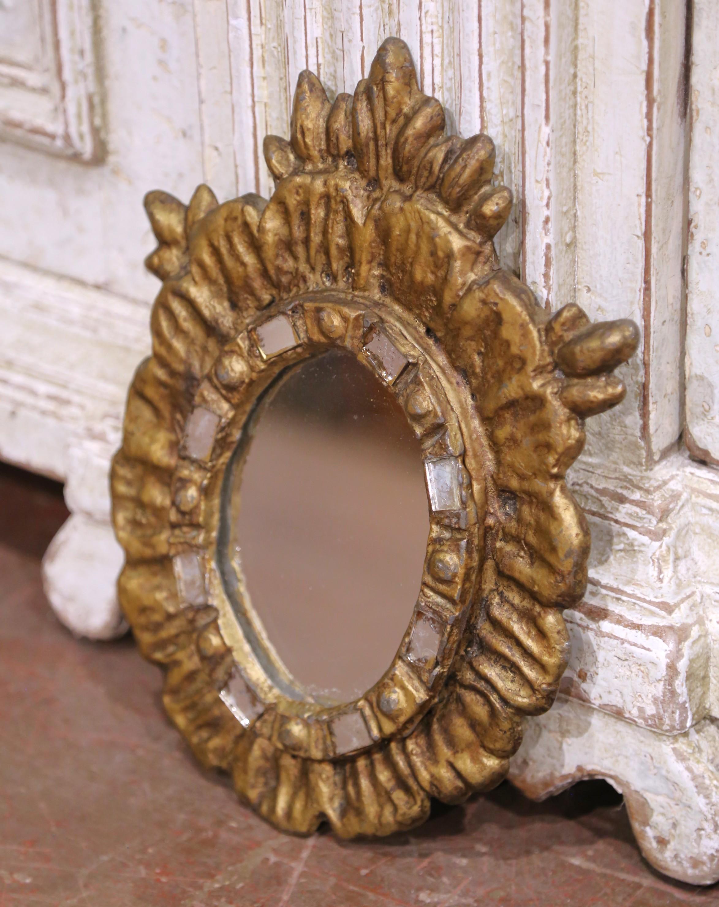 Ajoutez un accent radieux à votre espace avec ce petit miroir antique en forme de soleil. Fabriquée en Espagne vers 1920, cette pièce de 8,5 pouces de large sur 11,25 pouces de haut est coulée en fer lourd et finie dans un ton chaud de doré