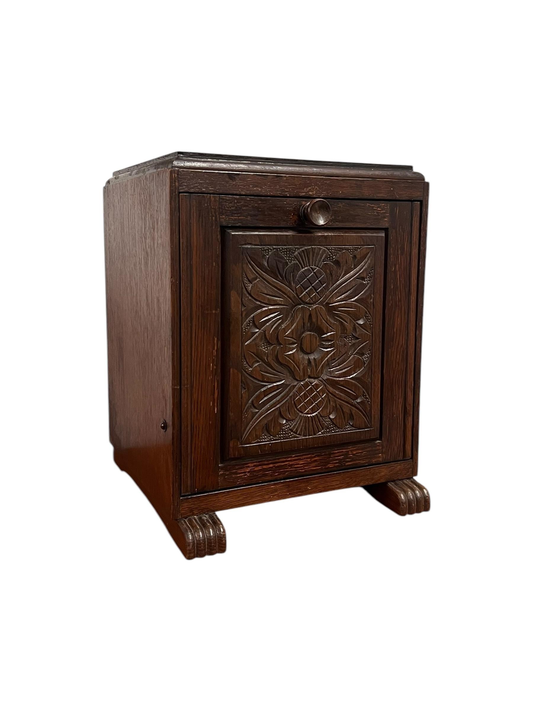 La carbonera inglesa tallada que aparece en las imágenes muestra un diseño encantador y funcional típico de los muebles de principios del siglo XX. Fabricada en madera rica y oscura, la papelera destaca por su robusta construcción y presenta