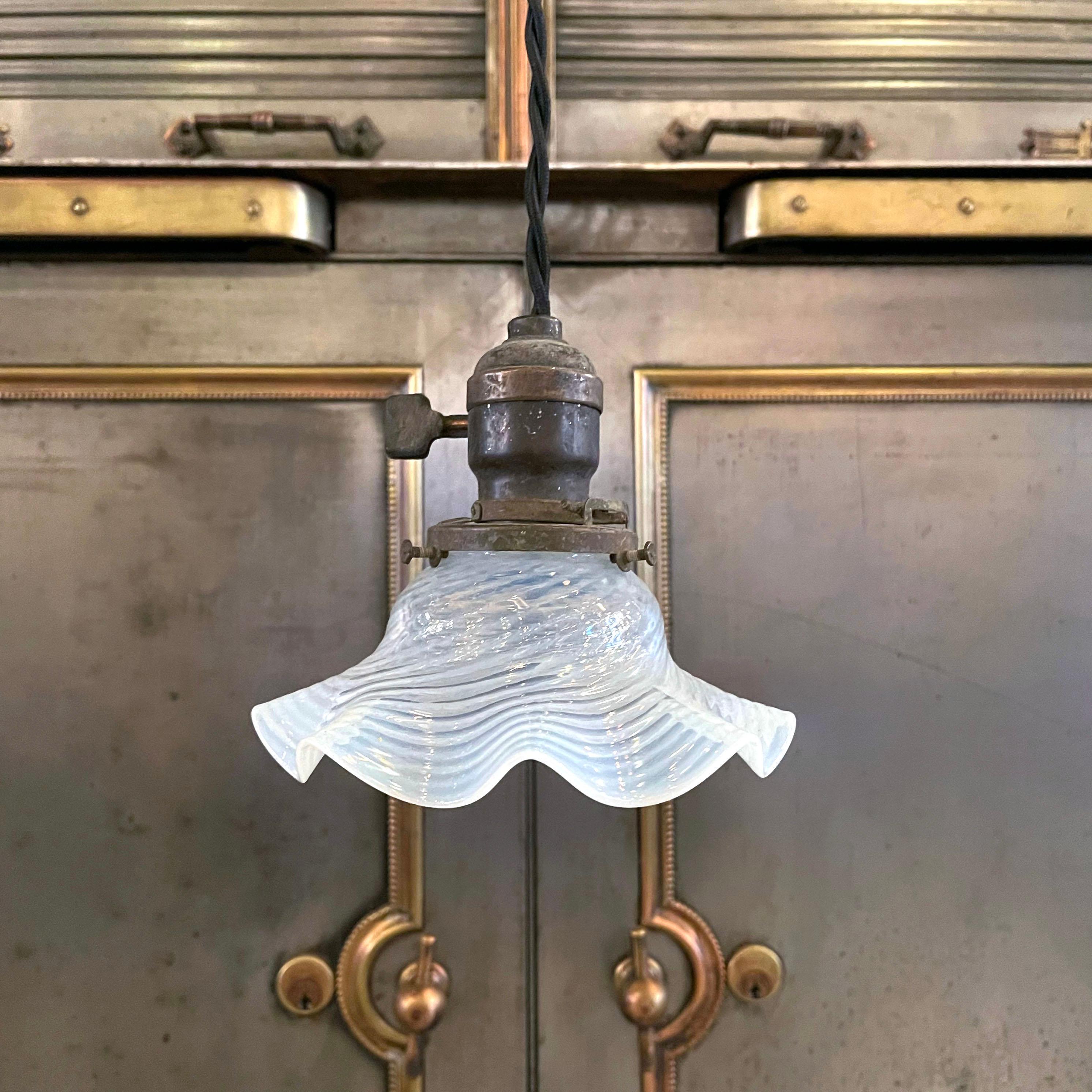 Petitie, early 20th century pendant light with opaline ruffle shade and brass paddle switch fitter is newly wired with black braided cloth cord to hang 52 inches at full length.