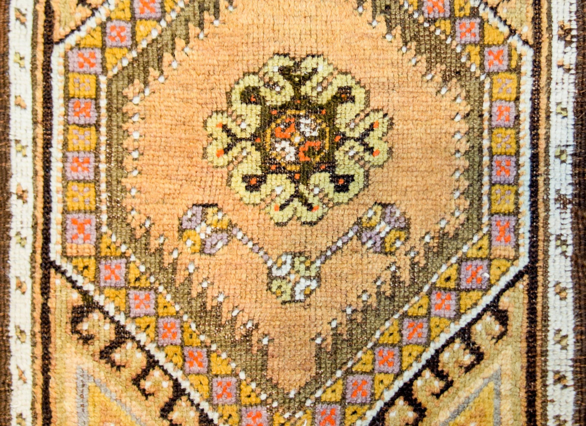 A petite early 20th century Turkish Oushak rug with a wonderful pattern woven in pastel orange, gold, brown, and cream colored wool. The border is thin, composed of a thin white stripe and an even thinner orange stripe.
