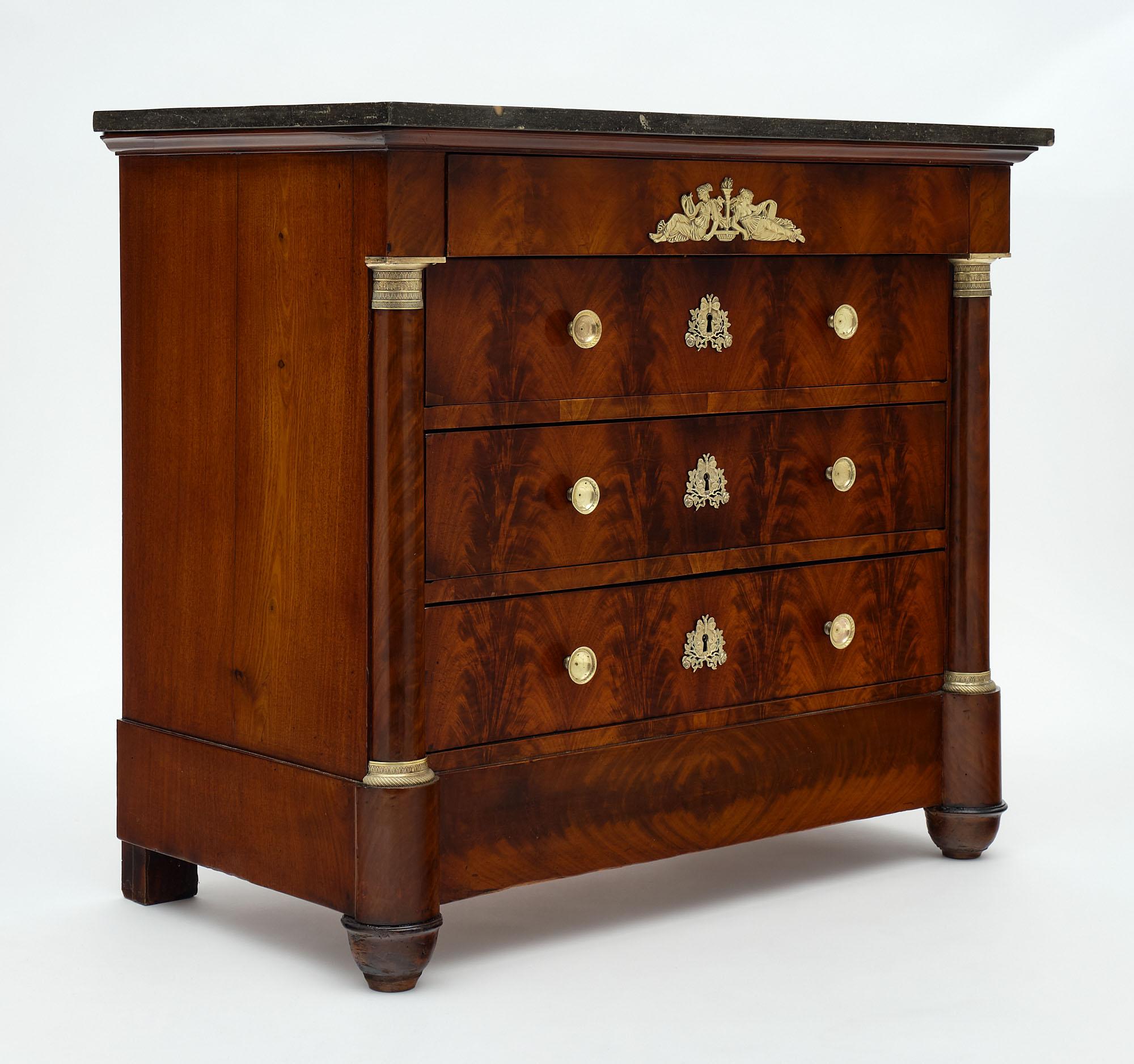 Petite chest of drawers from France made of flamed Cuban mahogany with four dovetailed drawers and a rich array of finely cast bronze hardware. The commode features half detached columns and is finished with a lustrous museum-quality French polish.