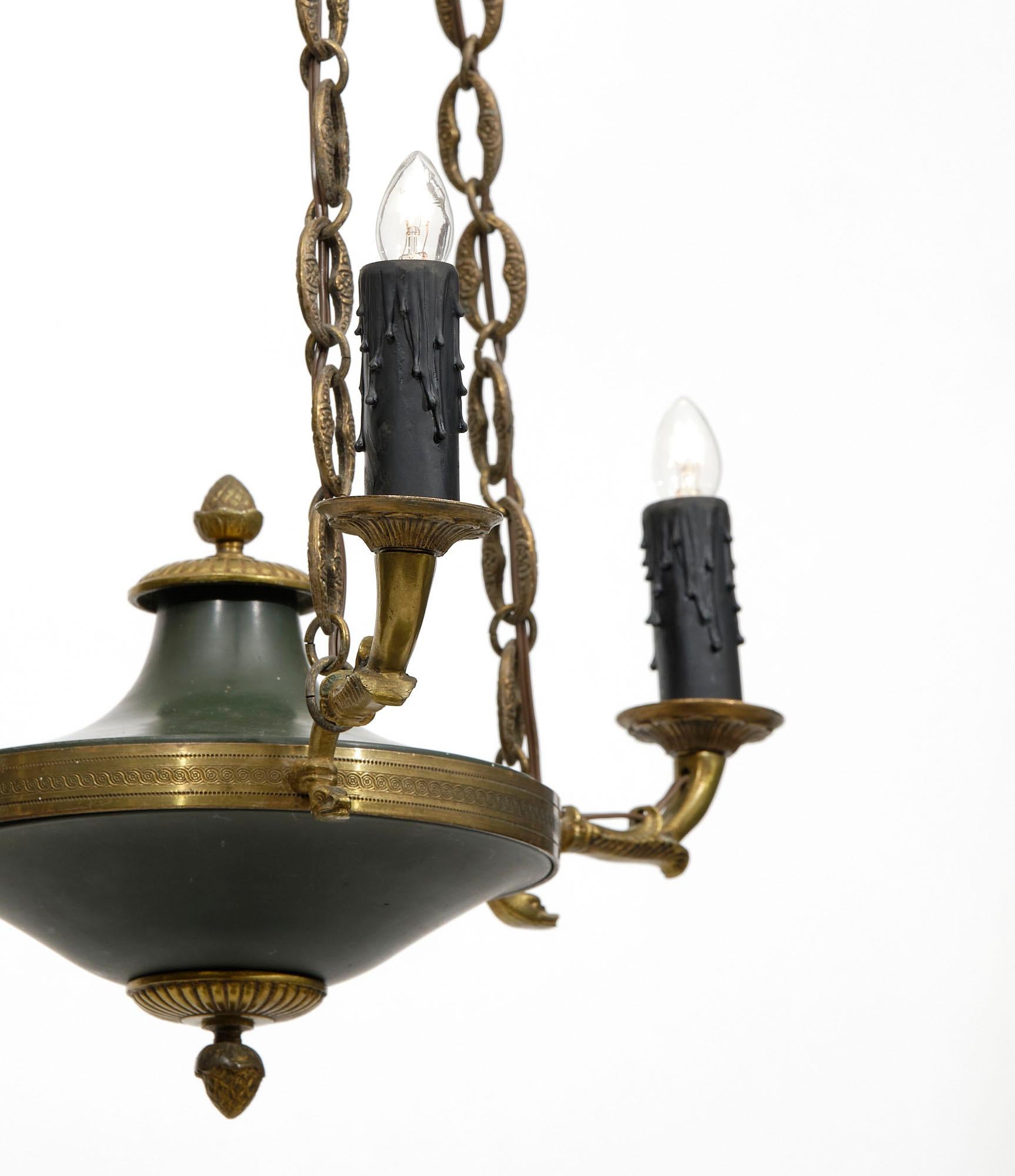 Chandelier from France in the Empire style. This refined fixture features three arms of the finest gilt bronze case with an acorn finial and original chains and canopy. It has been newly wired to fit US standards.