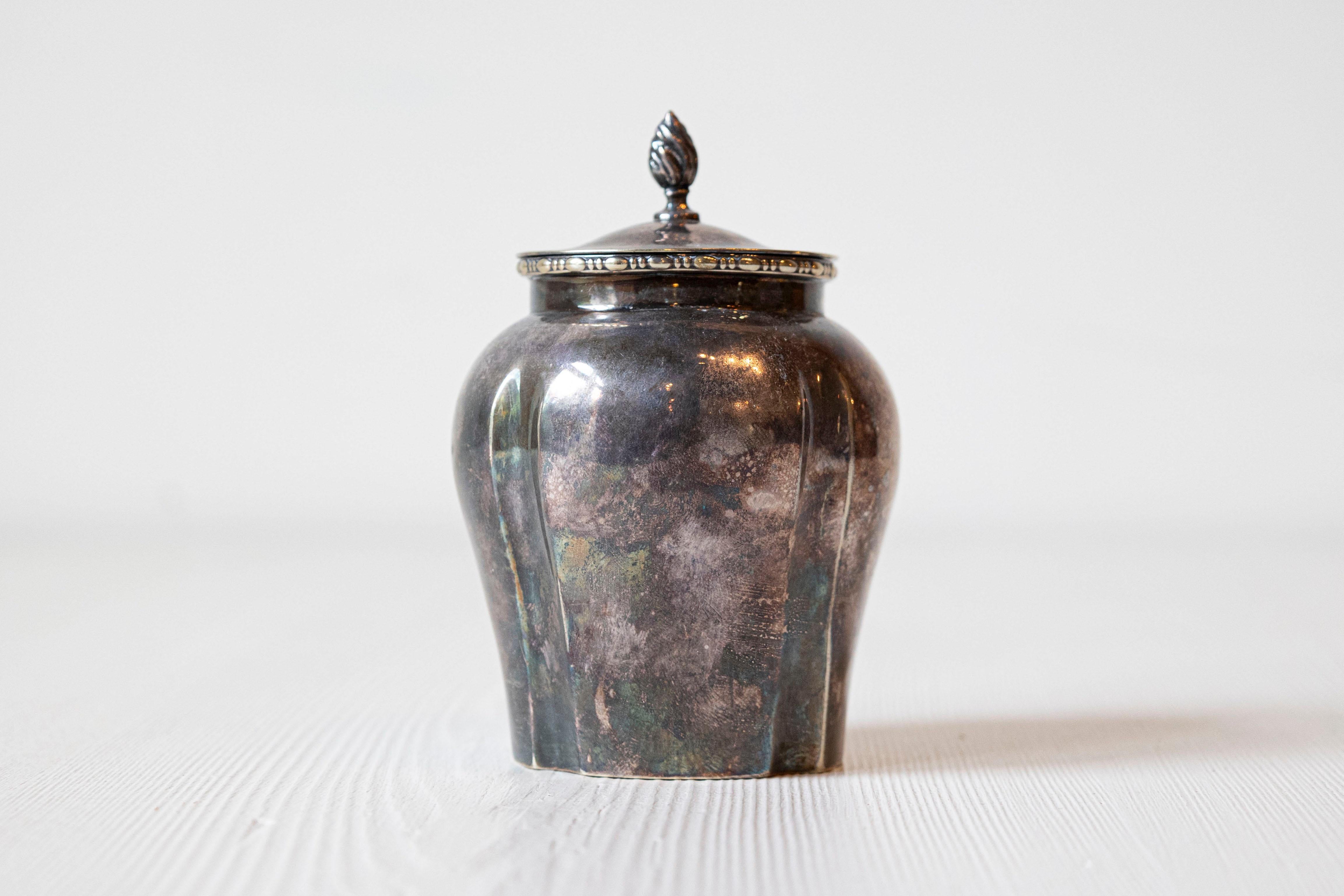 Un piccolo contenitore inglese con coperchio in nichel galvanico e argento del 20° secolo, con finalino fiammeggiante e motivi di perline e mulinelli. Creato in Inghilterra durante il XX secolo, questo piccolo contenitore presenta un coperchio