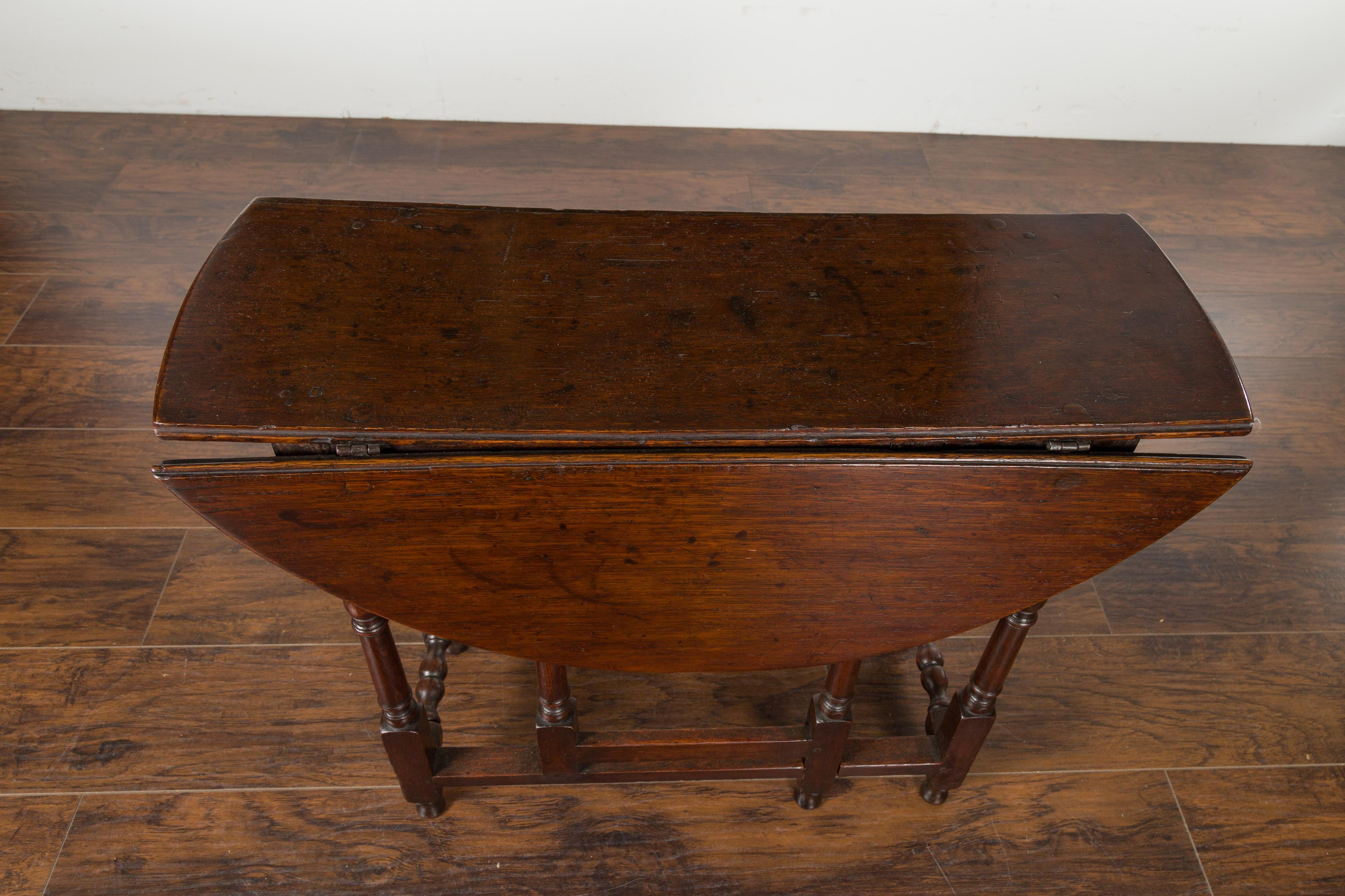 Turned Petite English Oval Oak 19th Century Drop-Leaf Table with Baluster Legs For Sale