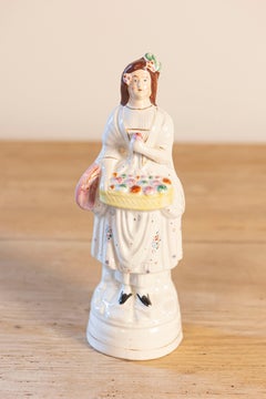 Petite English Porcelain Decorative Object Depicting a Lady with a Floral Basket
