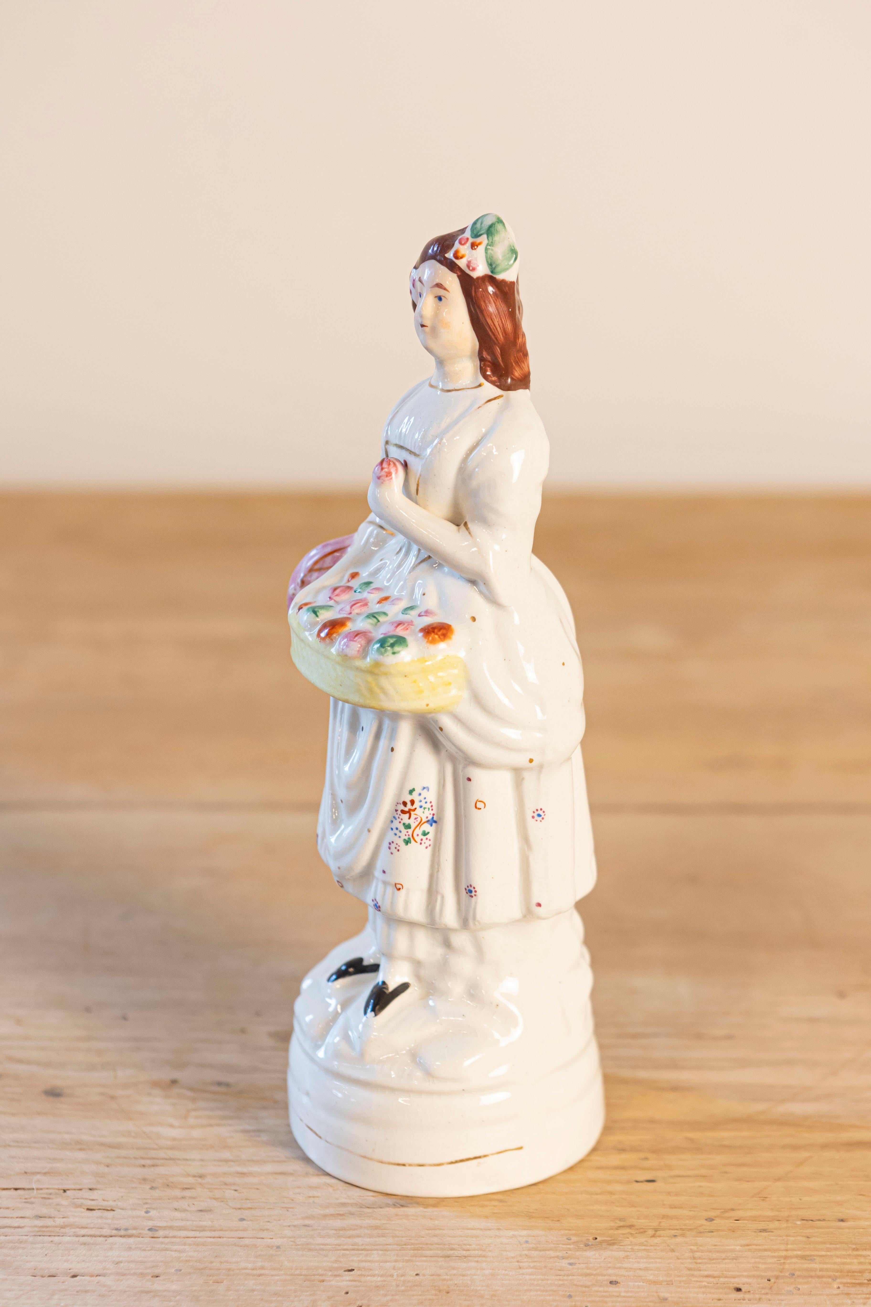 Painted Petite English Porcelain Decorative Object Depicting a Lady with a Floral Basket For Sale
