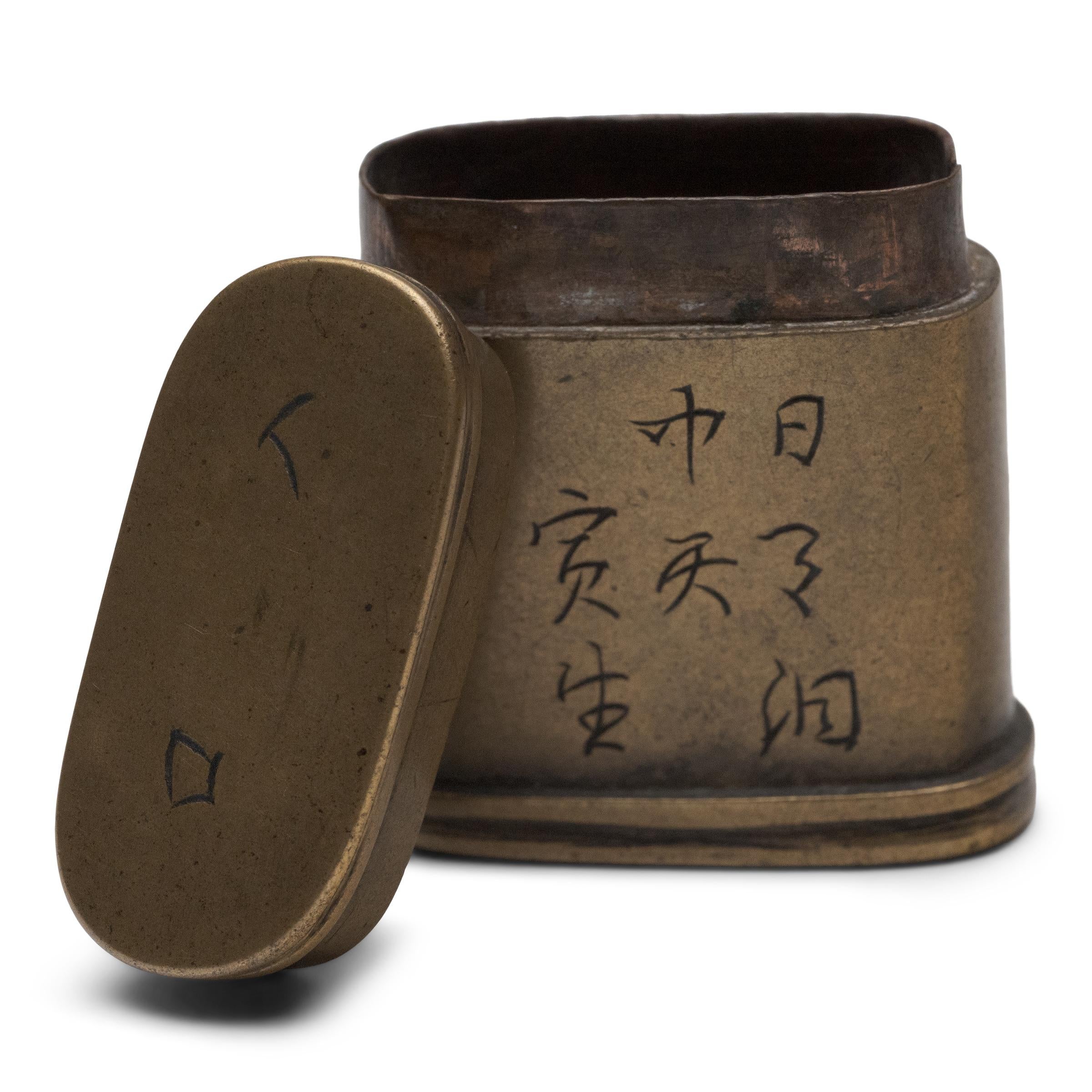 A petite 19th-century canister once used to store a smoker's personal supply of opium paste. A keepsake from a bygone era, the small box is formed of brass with a copper interior and is etched with painterly Chinese characters.