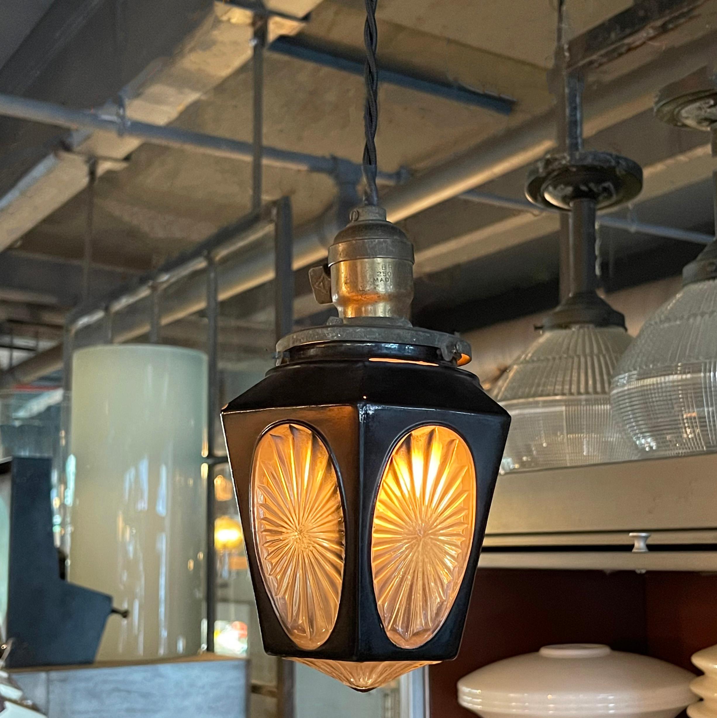 Petite, craftsman, pendant light features a faceted black glass shade with cut glass cut-outs and bottom with brass paddle switch fitter. The pendant is newly wired with 36 inches of braided cloth cord to accept up to a 75 watt, medium socket bulb.