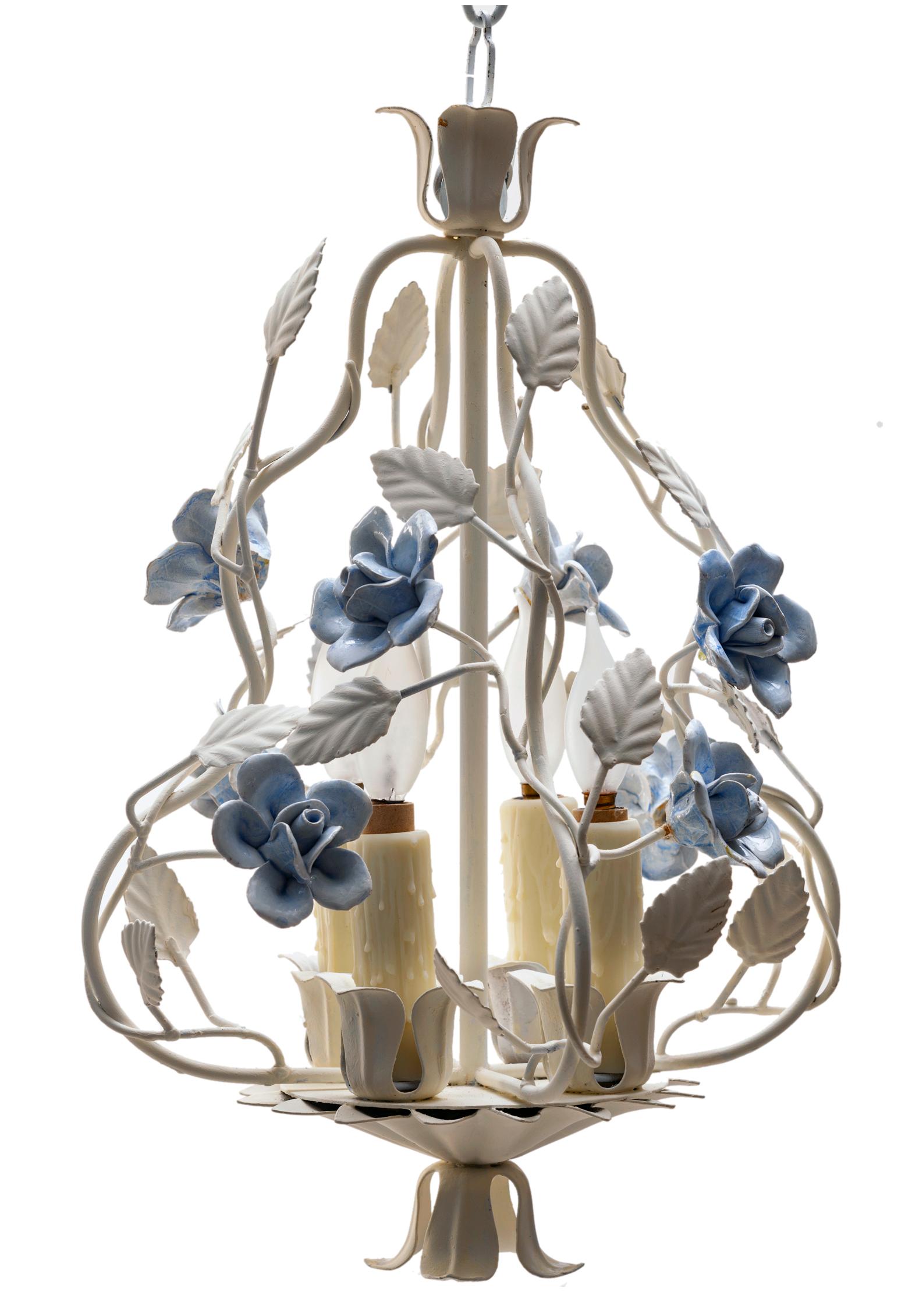 A tole chandelier with cornflower blue ceramic flowers, finger impressions on each hand made petal. CA srurreal cornflower blue rosehips are studded throughout.
Hand-painted metal tole frame with branches & leaves.
Rewired with an in line switch &