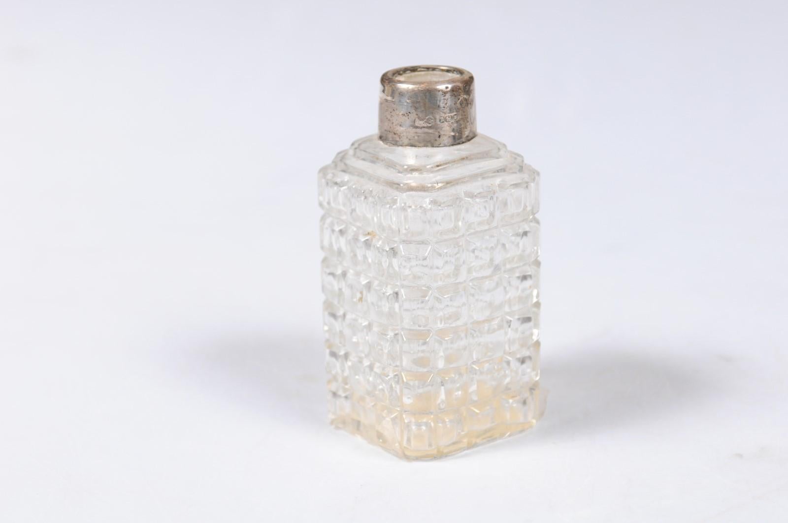 A French Napoleon III period petite crystal toiletry bottle from the mid-19th century, with silver neck. Born in France during the reign of Emperor Napoleon III, this lovely toiletry bottle features a rectangular body accented with raised motifs,