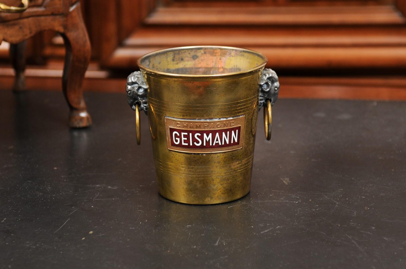 A small French brass champagne bucket from the 19th century, with Geismann label and rams' heads lateral handles. Created in France during the 19th century, this brass champagne bucket features a circular tapering body accented with lateral handles