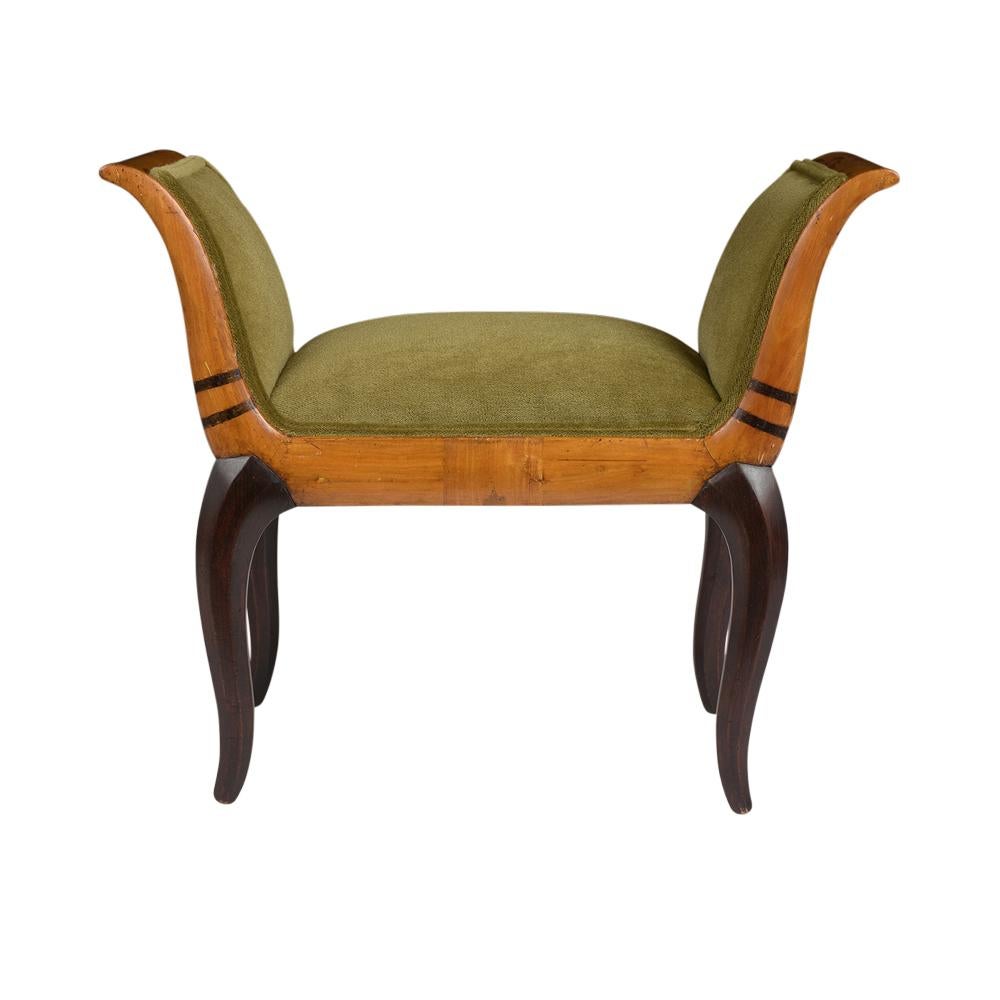 This French Petite Art Deco style footstool has been restored and new upholstery in a green color mohair fabric with double piping details. This footstool features a traditional Art Deco style design with carved inlay arms and the legs have an