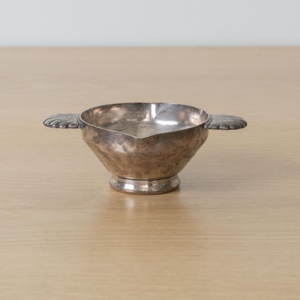 Precioso cuenco Art Déco de plata plateada procedente de Francia, años 30. Cuenco pequeño con un bonito detalle de concha en las asas. El acabado original muestra una gran antigüedad y pátina. Perfecto como objeto decorativo o cajón de sastre.