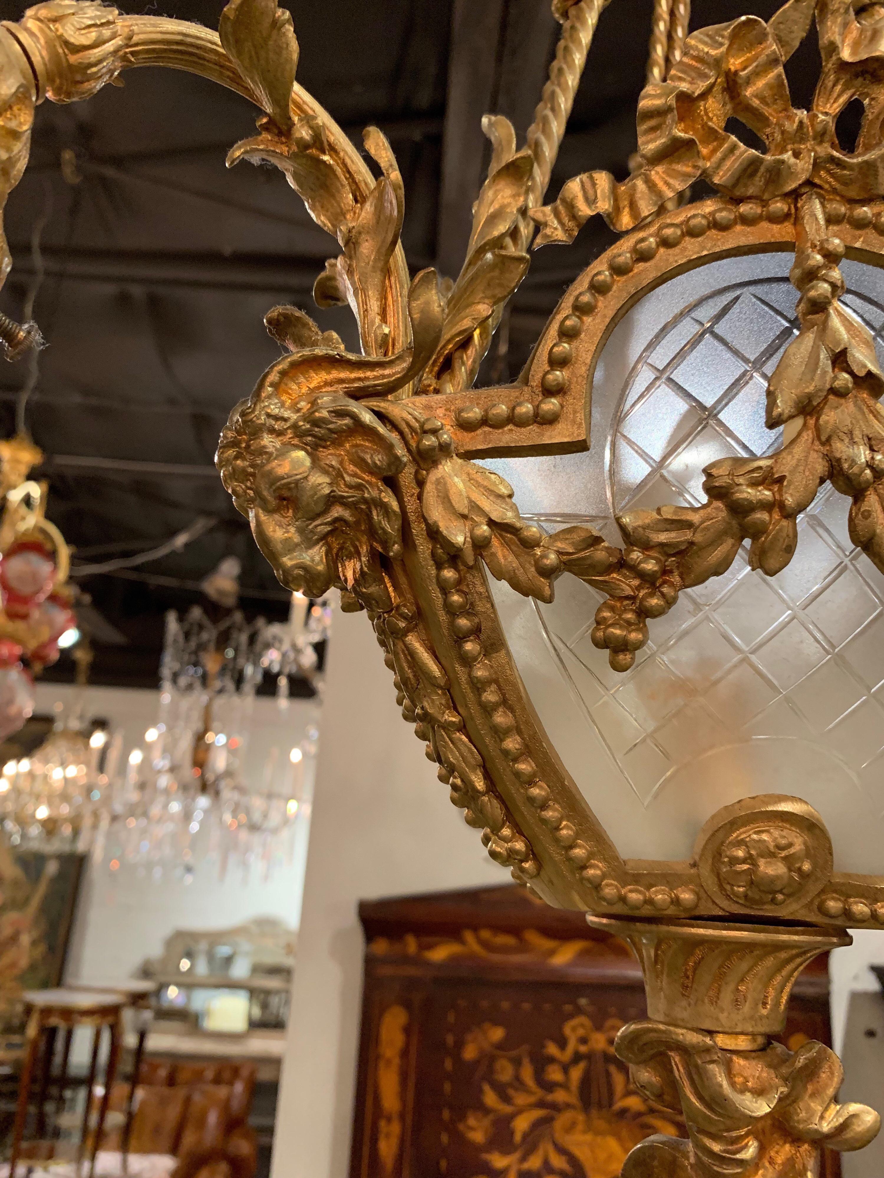 Beautiful petite French Belle Époque bronze 4-light chandelier. Very fine detail on the bronze with images including rope tassels, bows and rams. The fixture has frosted glasses shades and globe as well. A totally unique piece. Comes with a canopy