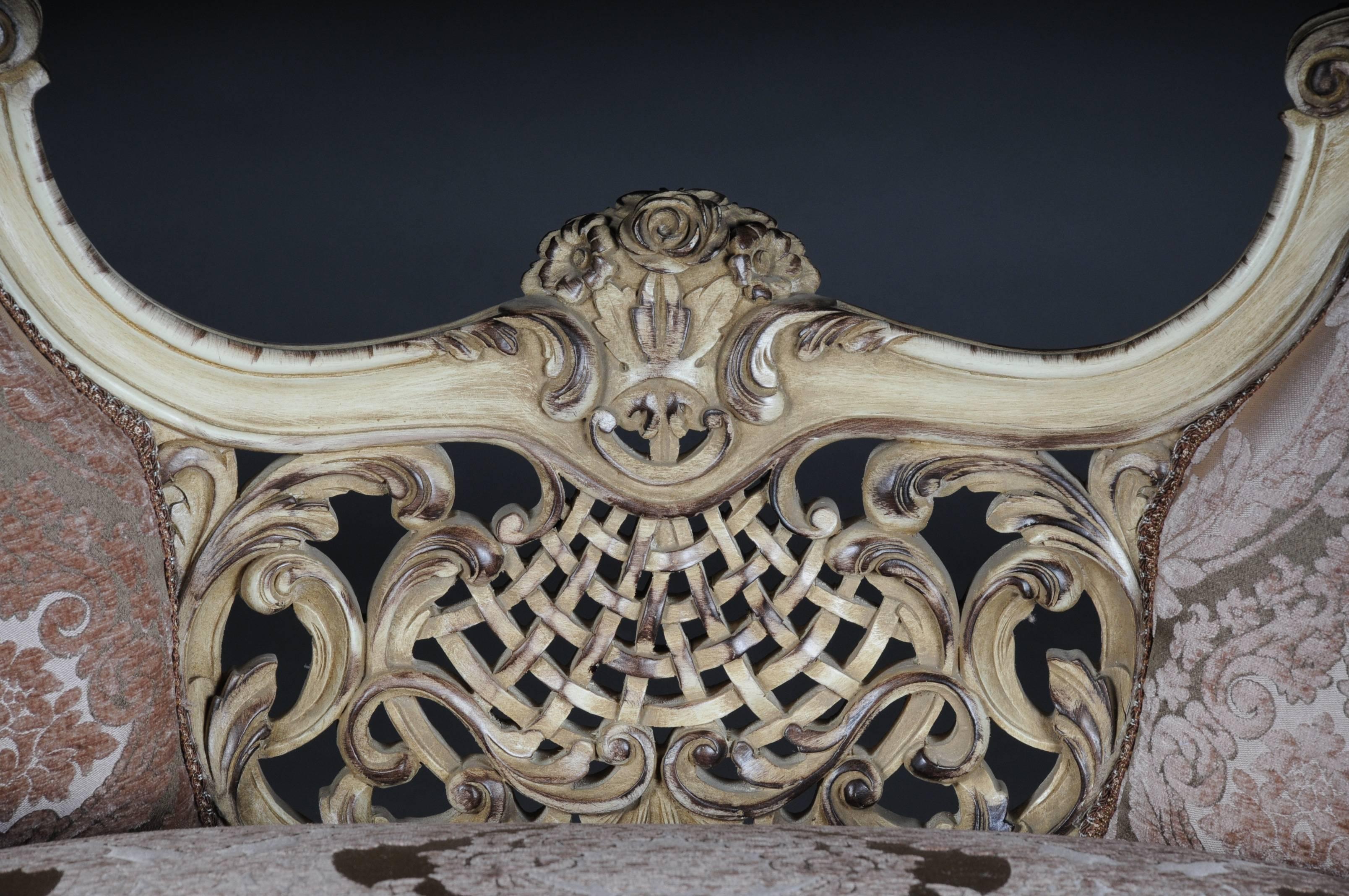 Solid beechwood, carved and gilt gilded. Semi circular rising, curved backrest framing with rocaille crowning. Appropriately curved frame with rich carved foliage. Profiled frame on curved legs. Seat and backrest are finished with a historical,
