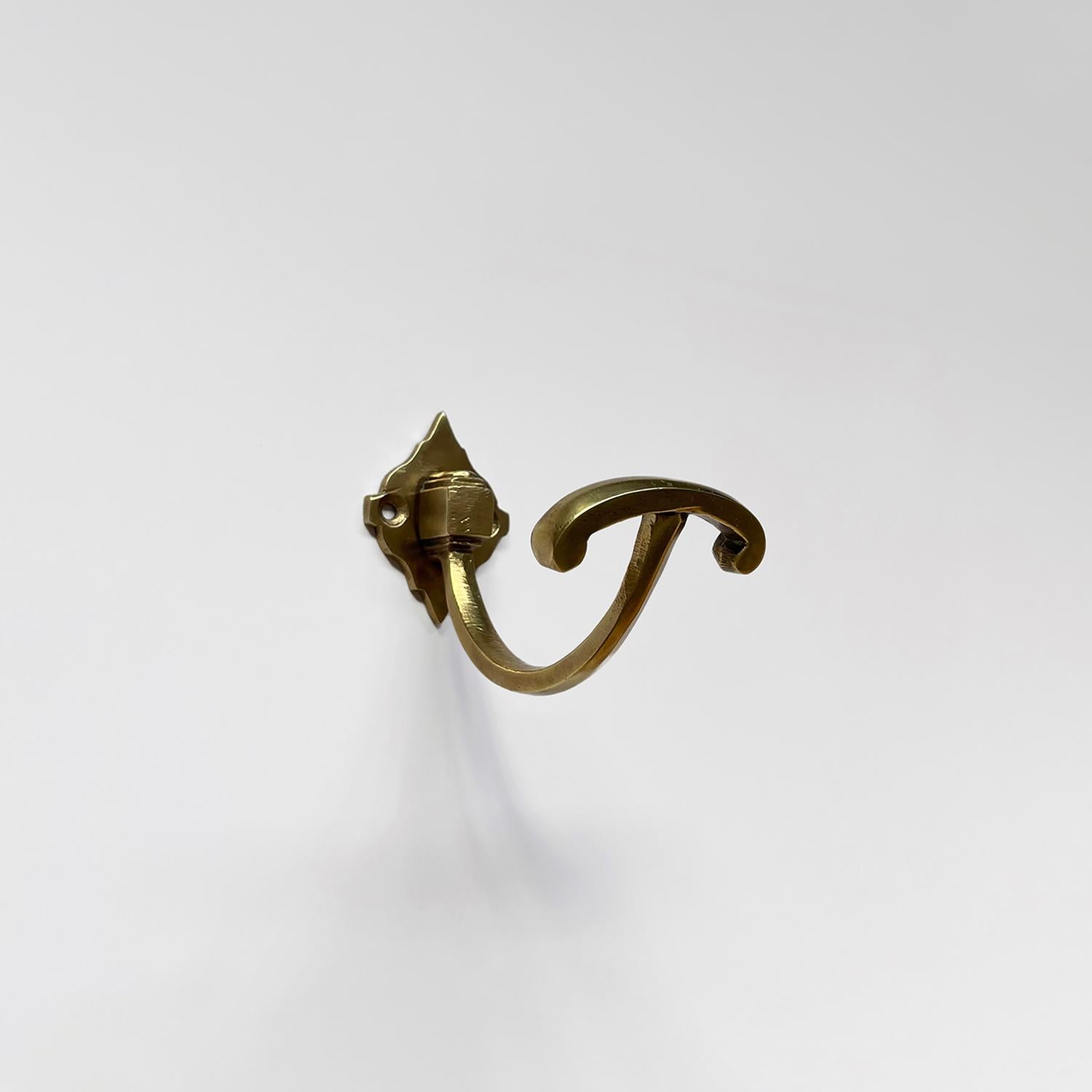 Petite French brass single wall hook
France, mid century
Single J hook is supported by a platform base and finished with an arched storage hook
Wall mounted hook is supported by a single diamond shaped bracket which requires two screws
Patina from