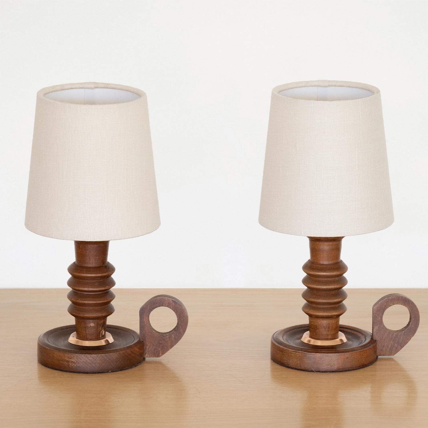 Petite wood table lamp from France, 1940s. Beautiful carved wood stem forms with circular base and small loop handle. All original wood finish. New linen shade and newly re-wired. Two available. Sold individually. Takes one E12 base bulb, 25 W or
