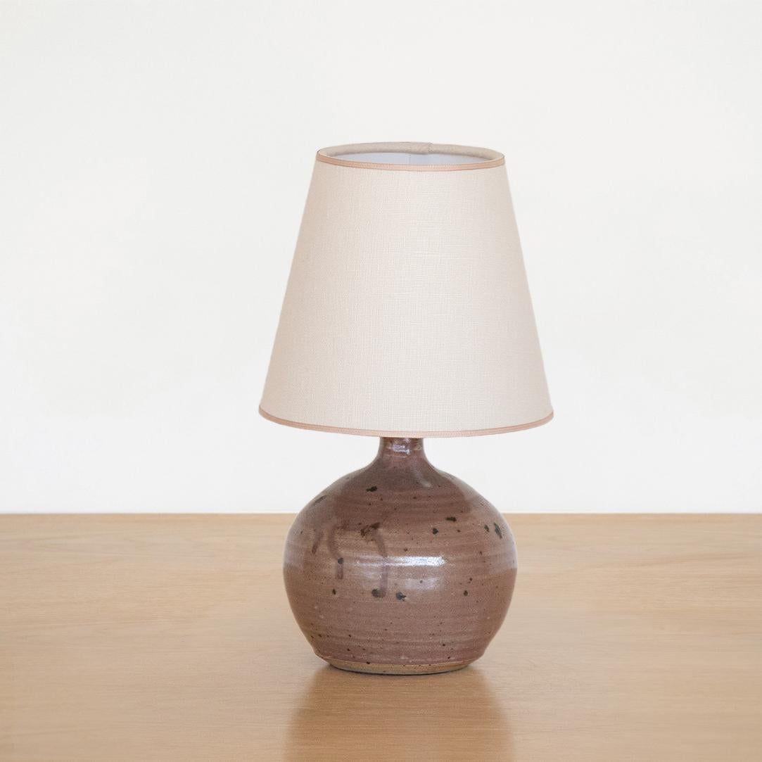 Vintage petite ceramic lamp from France, 1960's. Glazed ceramic in light brown coloring. Newly rewired with new linen shade with tan trim.