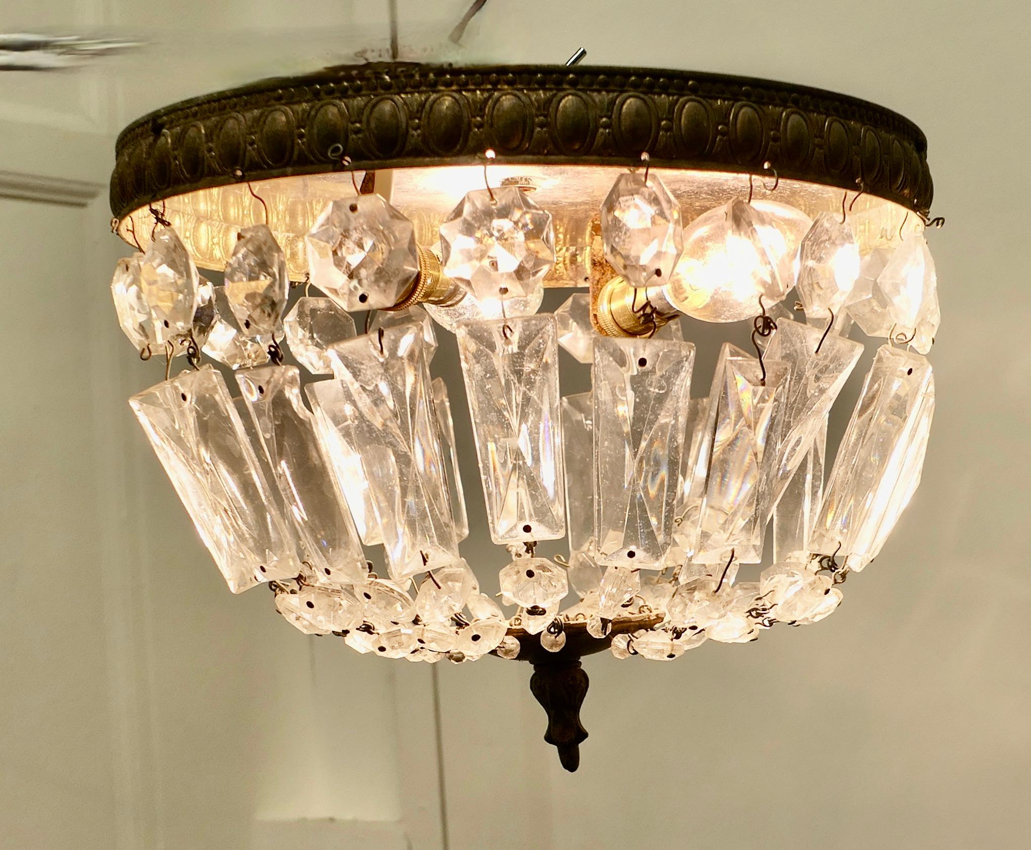 Petite French Empire Style Crystal Basket Chandelier

This is a lovely little piece it has twin bulbs with a mirror behind  and a brass frame hung with chains forming a basket and a brass roundel forming the base
The Chandelier is in good working