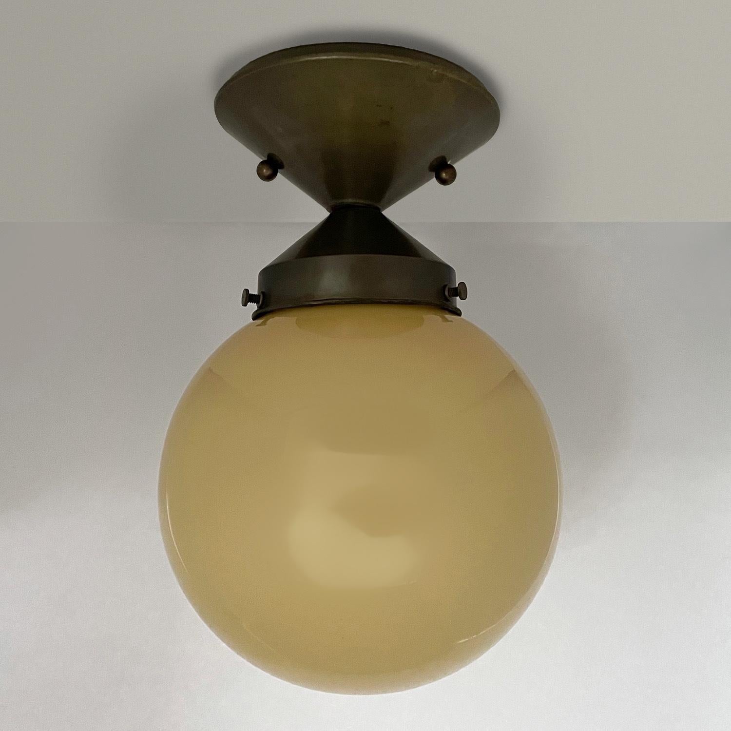 Petite French globe light
France, circa 1940s
This is a charming light fixture
Pale mustard glass globe
Bronzed conical base has light surface markings
Patina from age and use
Newly rewired single base medium bulb
Canopy has been upgraded to