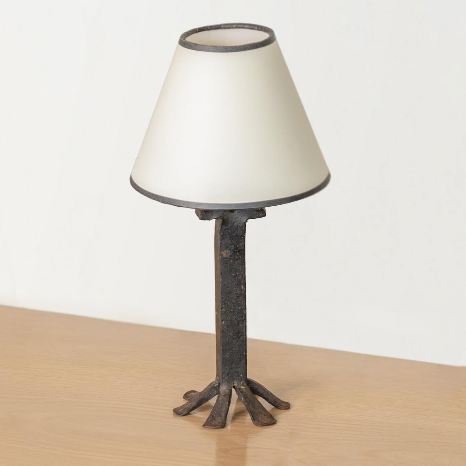 Unique French black iron table lamp with rectangular iron stem and six foot base. Newly re-wired and new paper shade with black trim.
